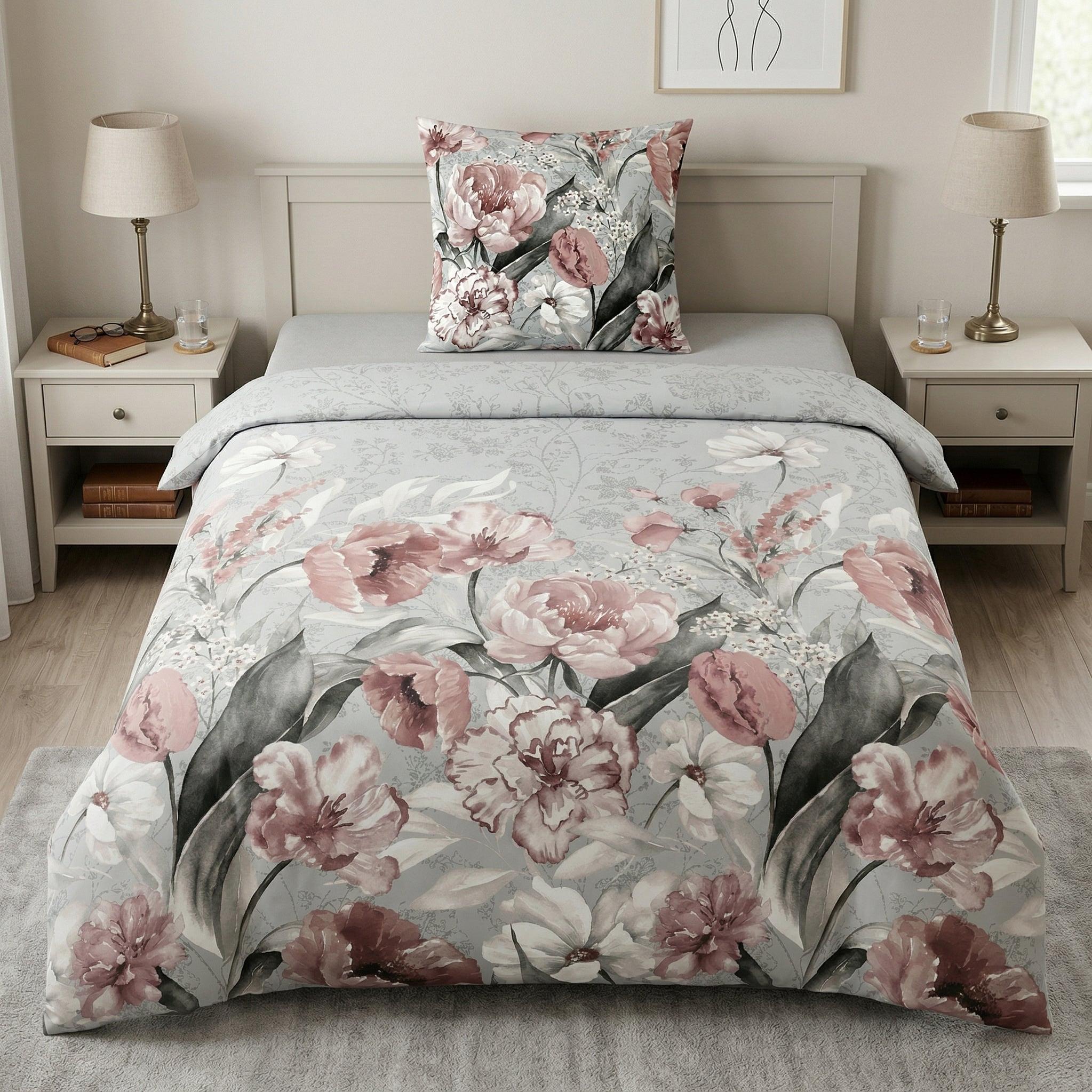 Blumige Bettwäsche in Rosa und Grau auf modernem Bett.