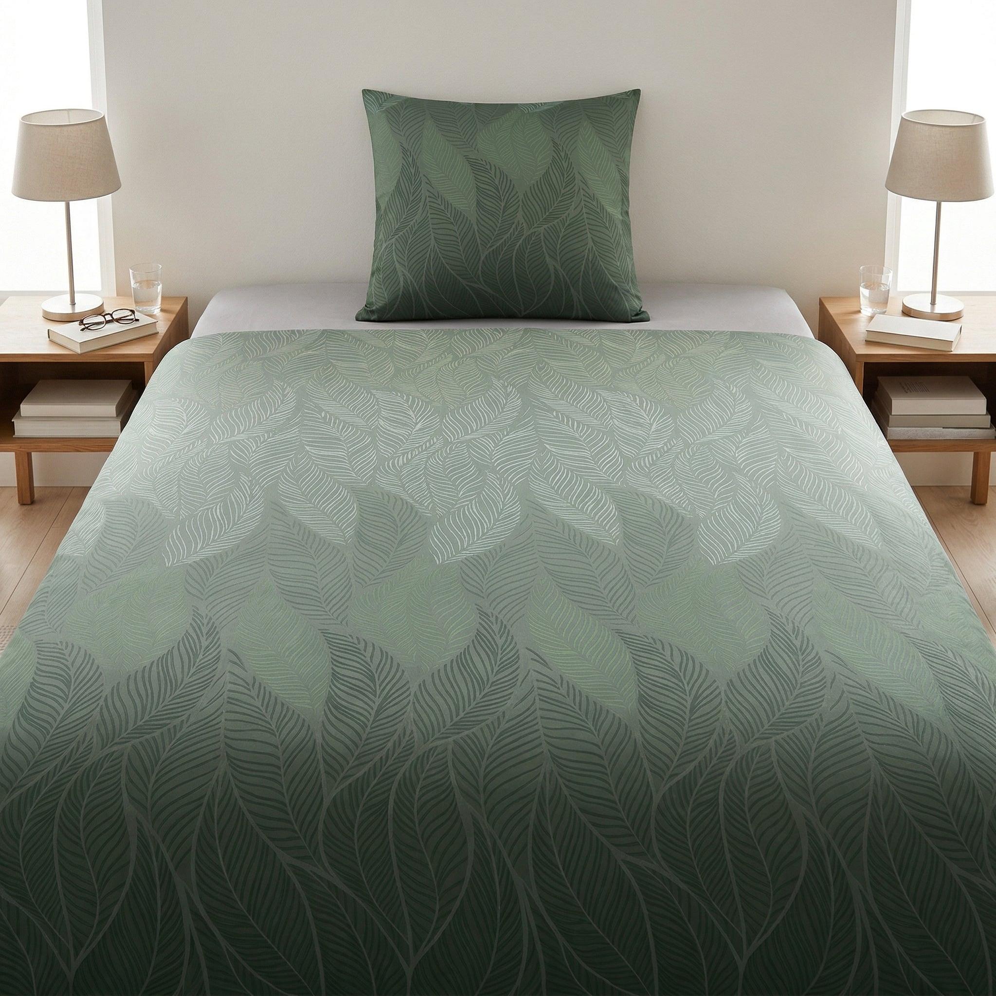 Grün gemusterte Bettwäsche mit Blättermotiv auf modernem Bett.