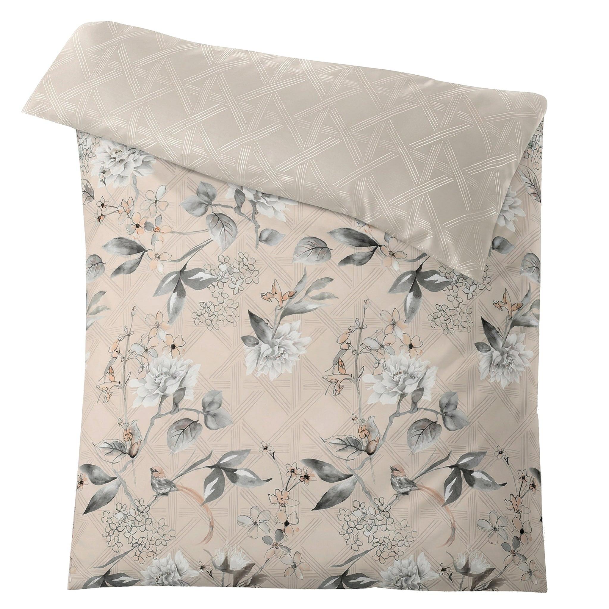Beige Bettwäsche mit grauem Blumenmuster und grafischer Rückseite.