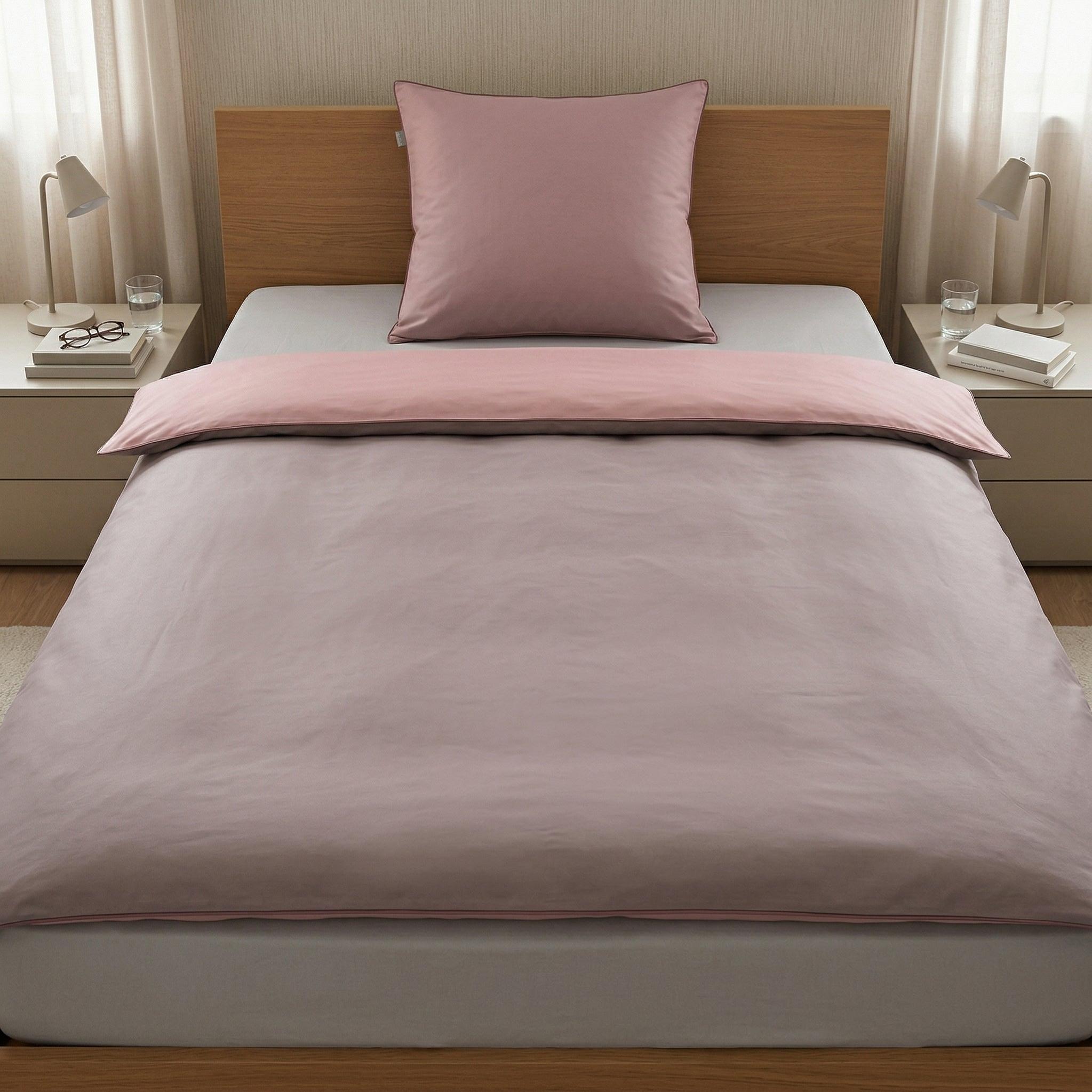 Rosa Bettwäsche mit Kissen auf modernem Bett im Schlafzimmer.