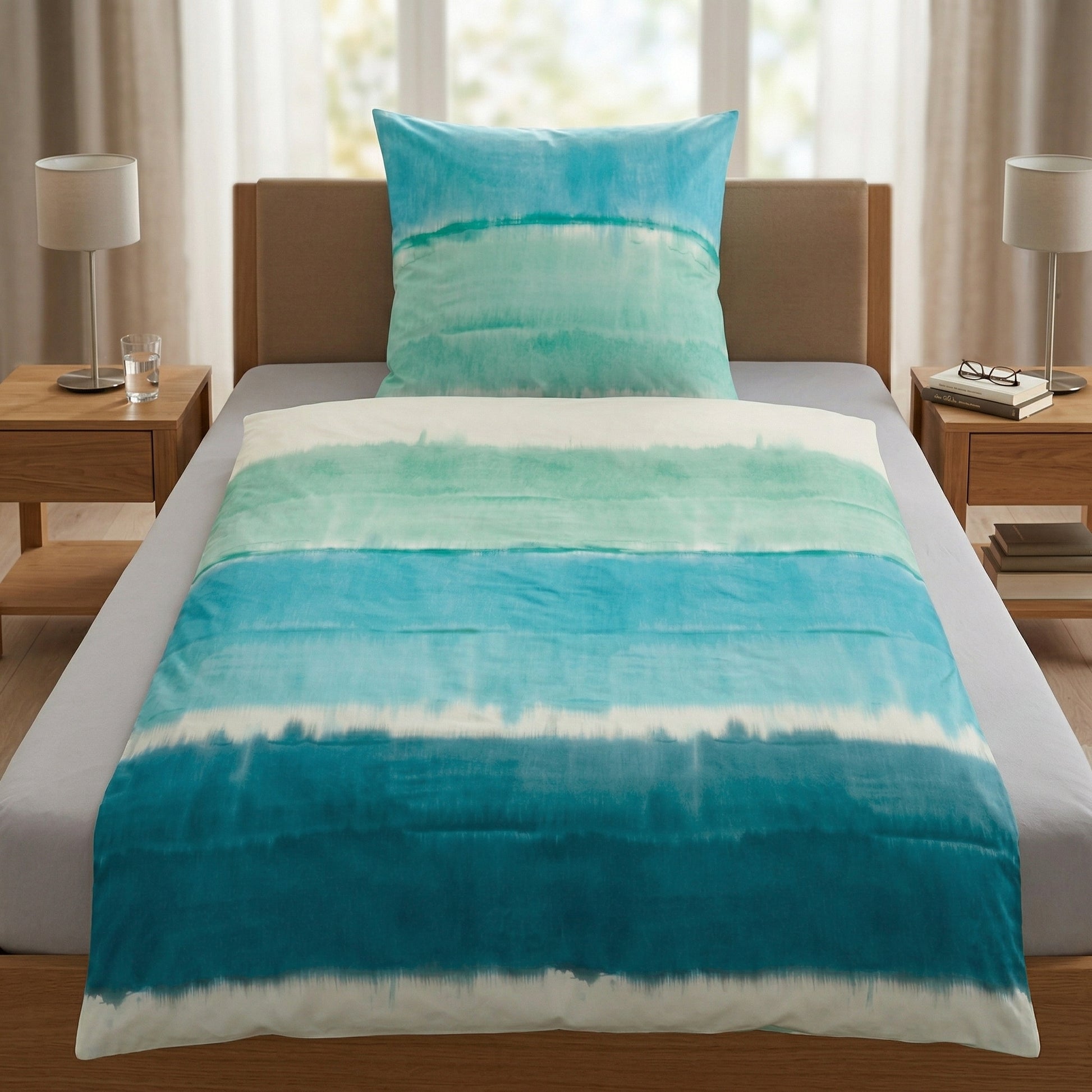 Bettwäsche mit blauem Aquarellmuster auf einem modernem Bett.