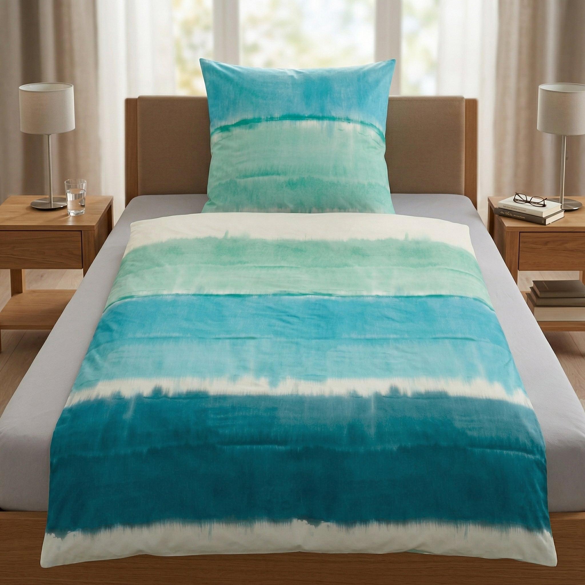 Bettwäsche mit blauem Aquarellmuster auf einem modernem Bett.