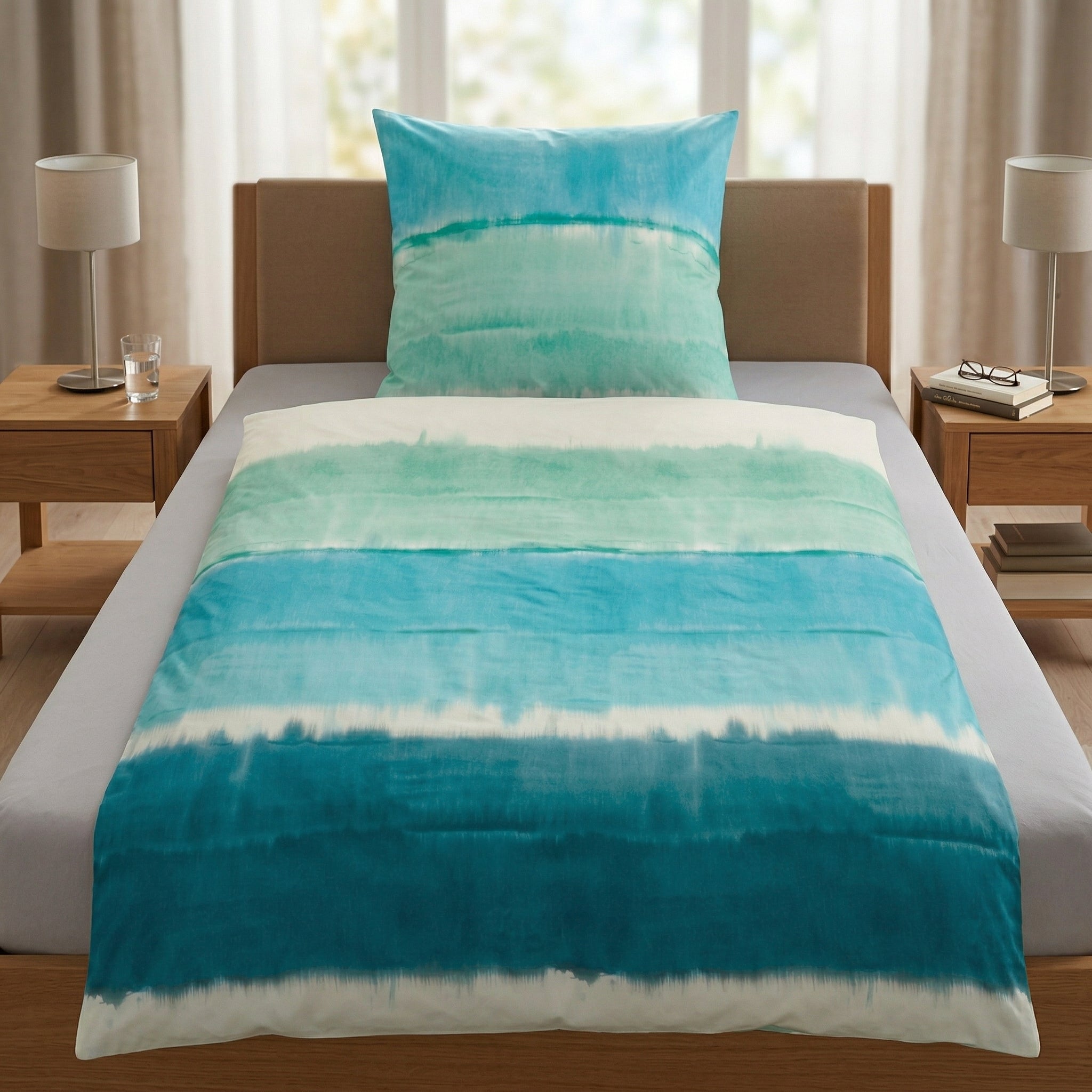 Bettwäsche mit blauem Aquarellmuster auf einem modernem Bett.