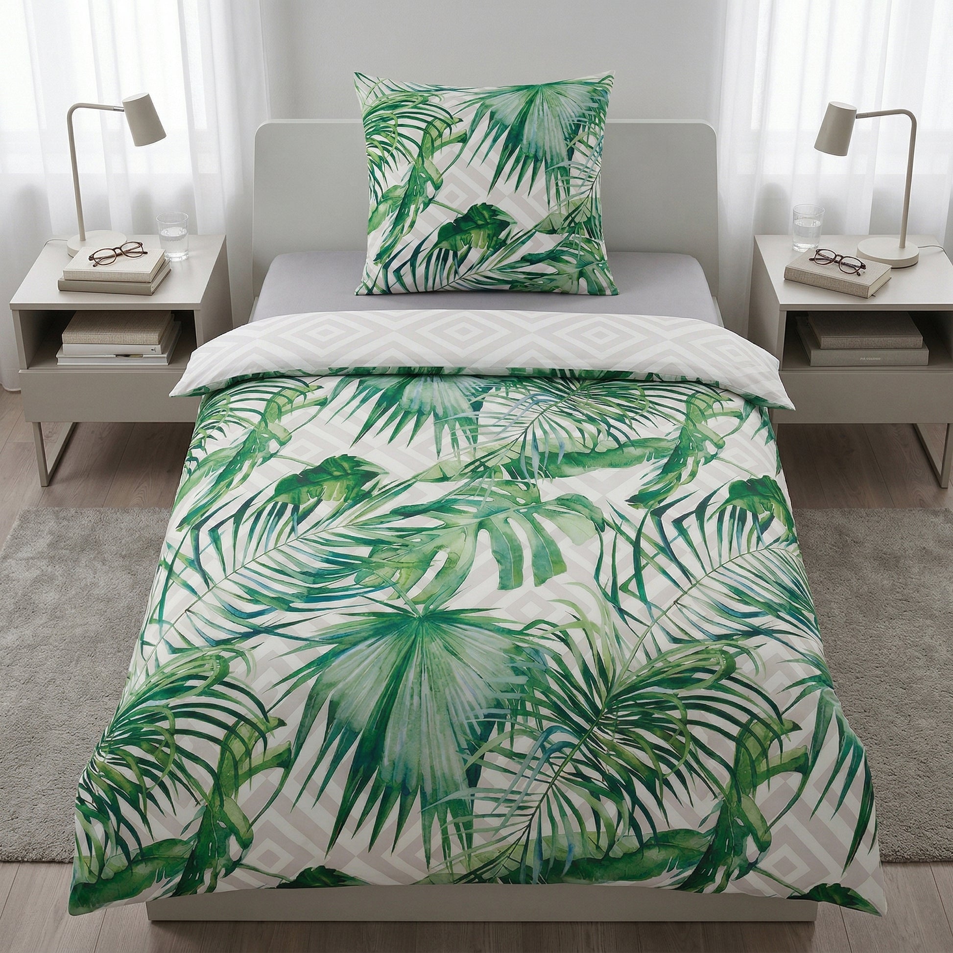 Bettwäsche mit grünem Blättermuster auf weißem Bett.