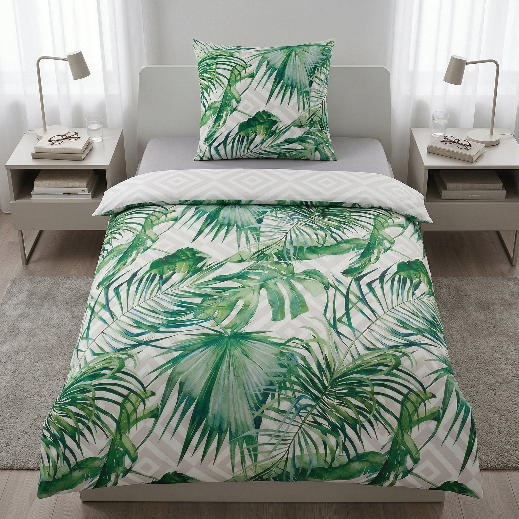 Bettwäsche mit grünem Blättermuster auf weißem Bett.
