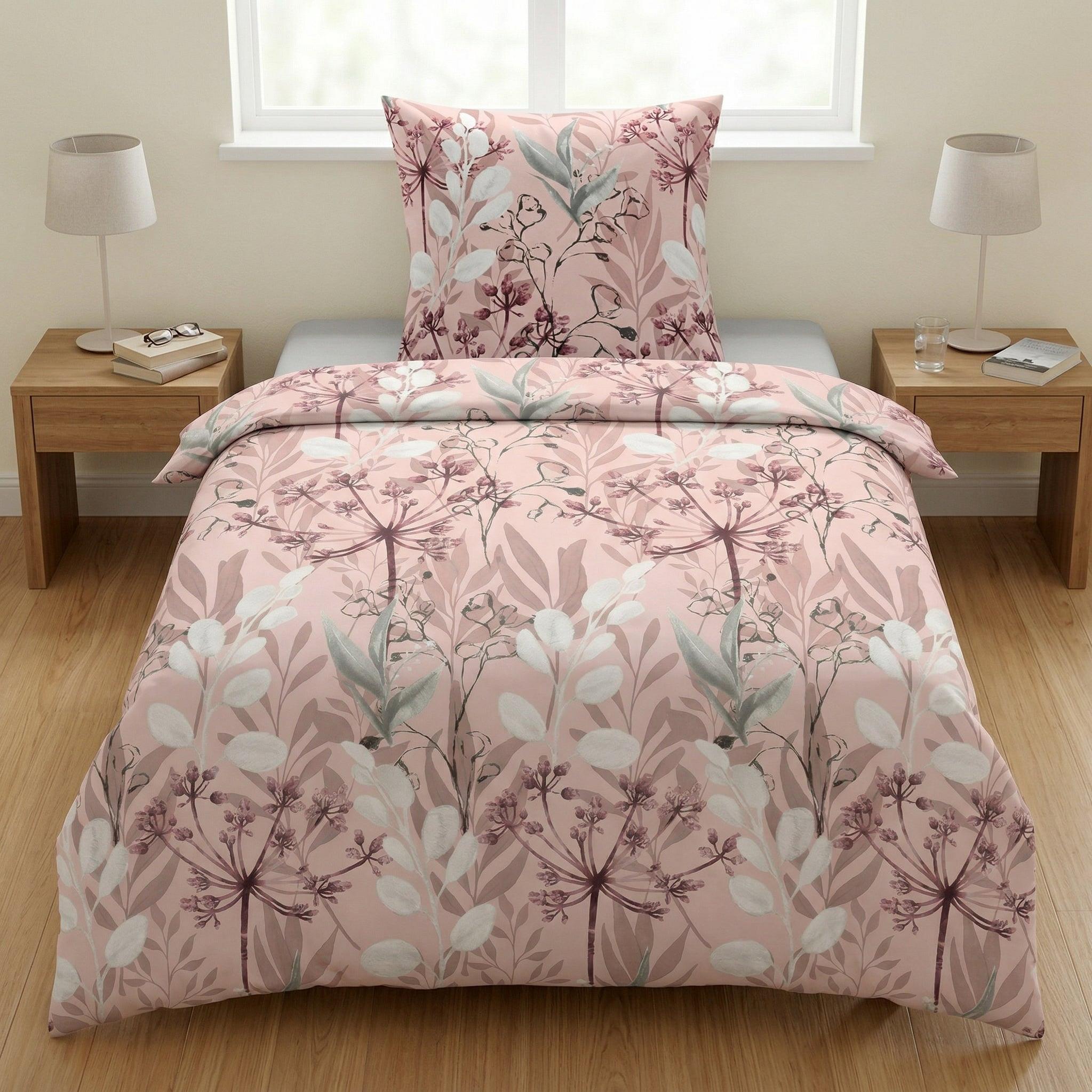 Rosa Bettwäsche mit floralem Muster auf einem gemachten Bett.