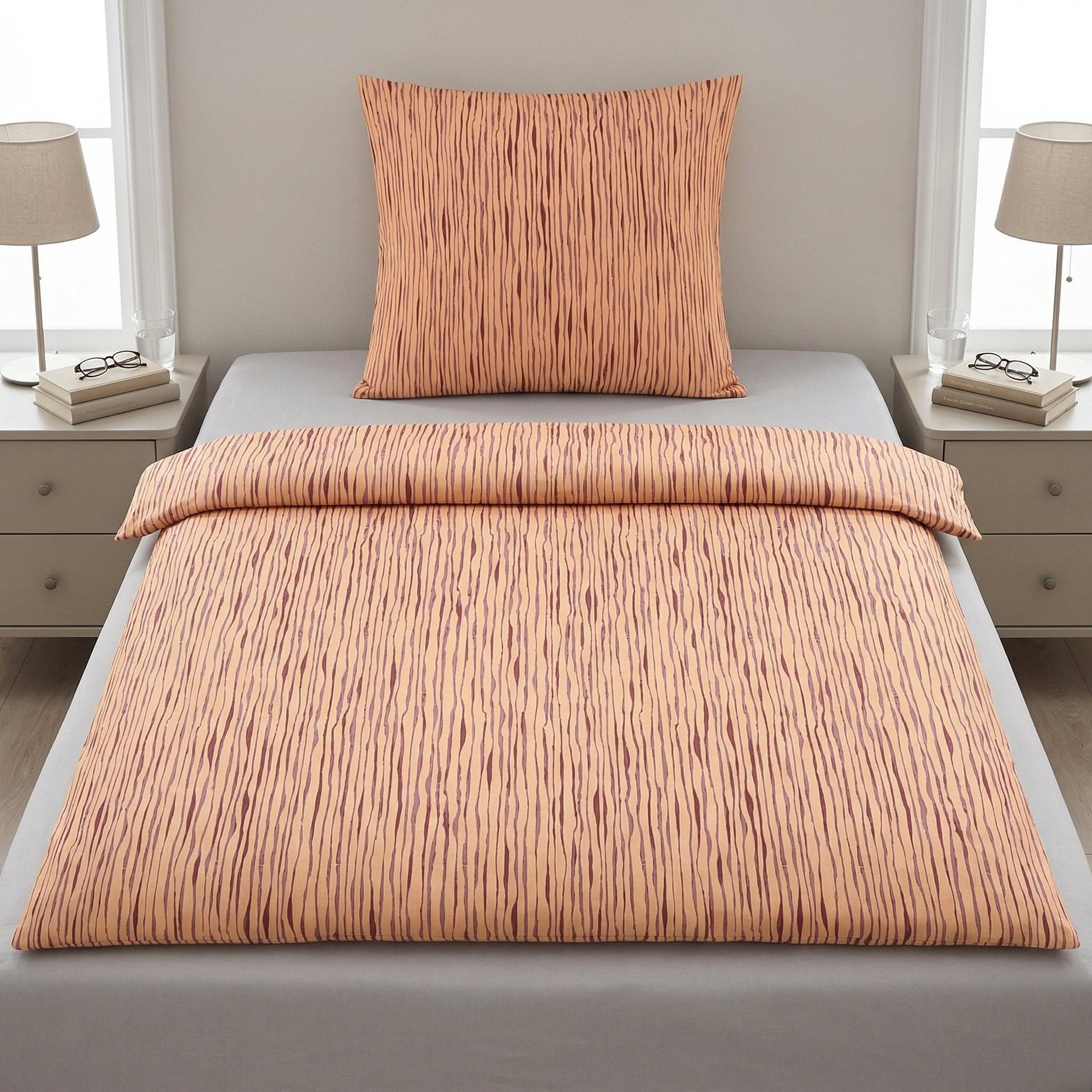 Gestreifte Bettwäsche in Apricot auf einem modern gemachten Bett.