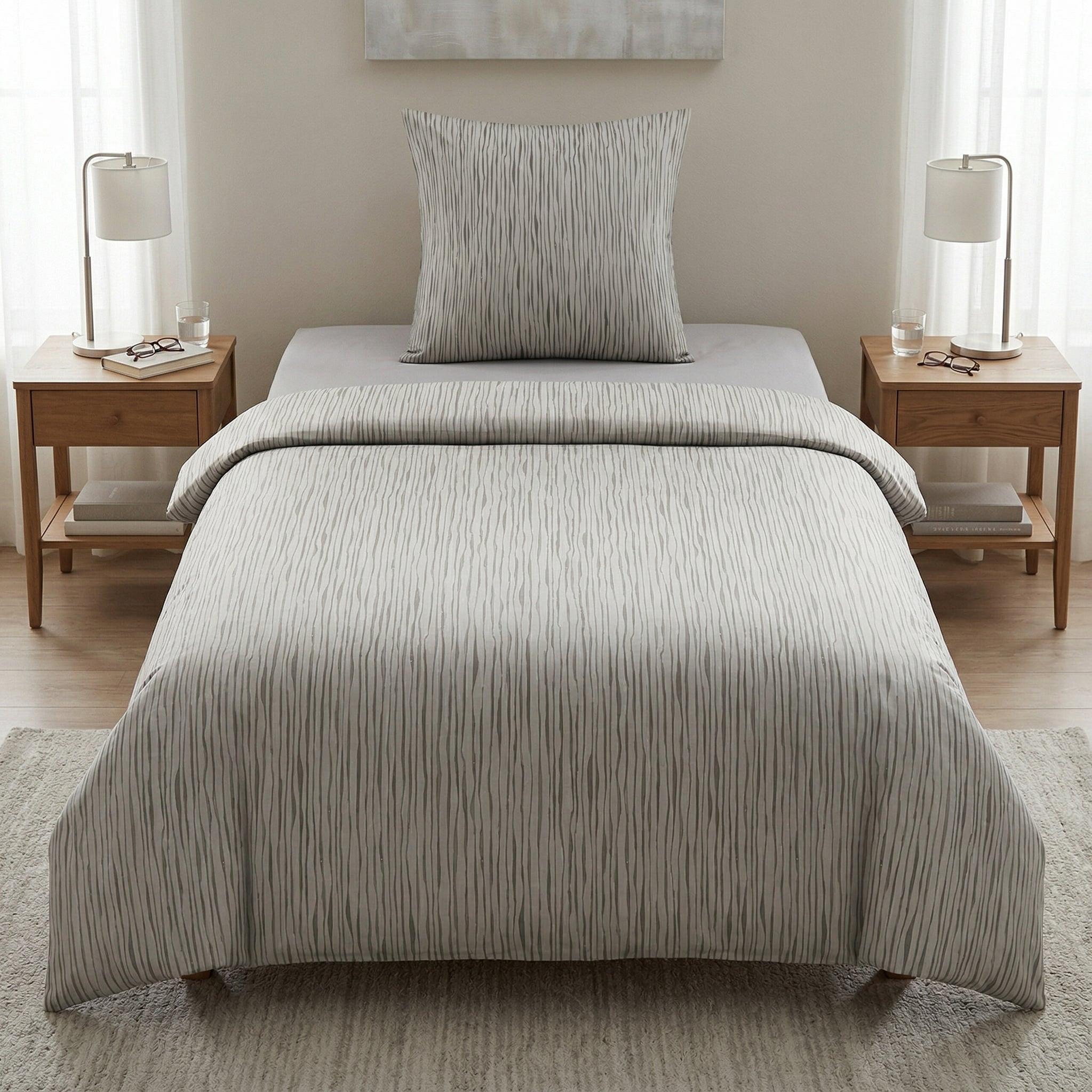 Graue Bettwäsche mit feinem Streifenmuster in hellem Schlafzimmer.