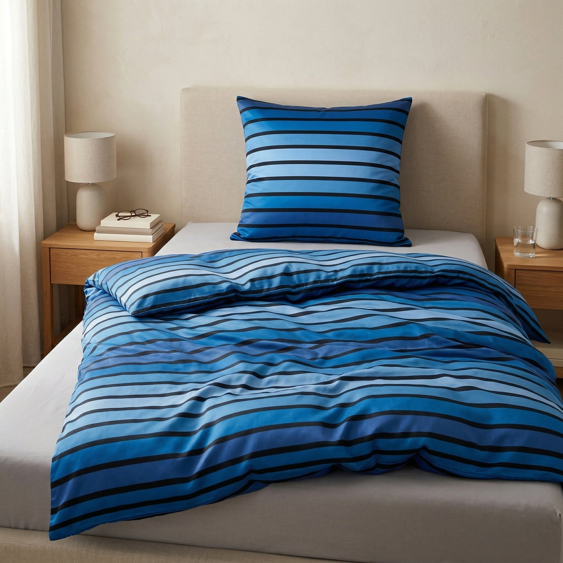 Blau gestreifte Bettwäsche auf modernem Bett im Schlafzimmer.