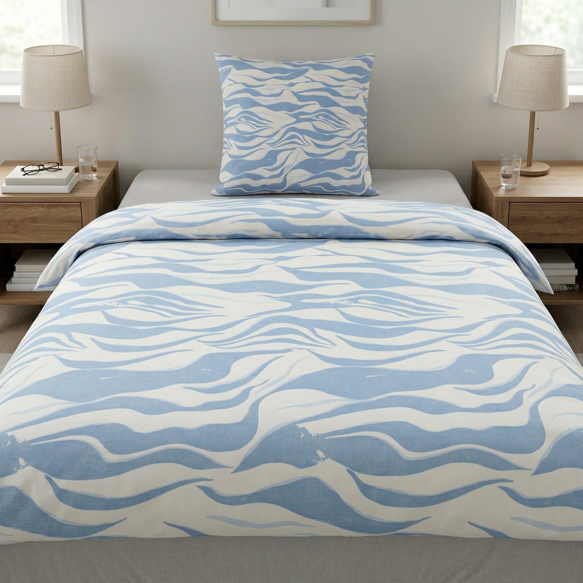 Bettwäsche in Weiß und Hellblau mit Wellenmuster im Schlafzimmer.