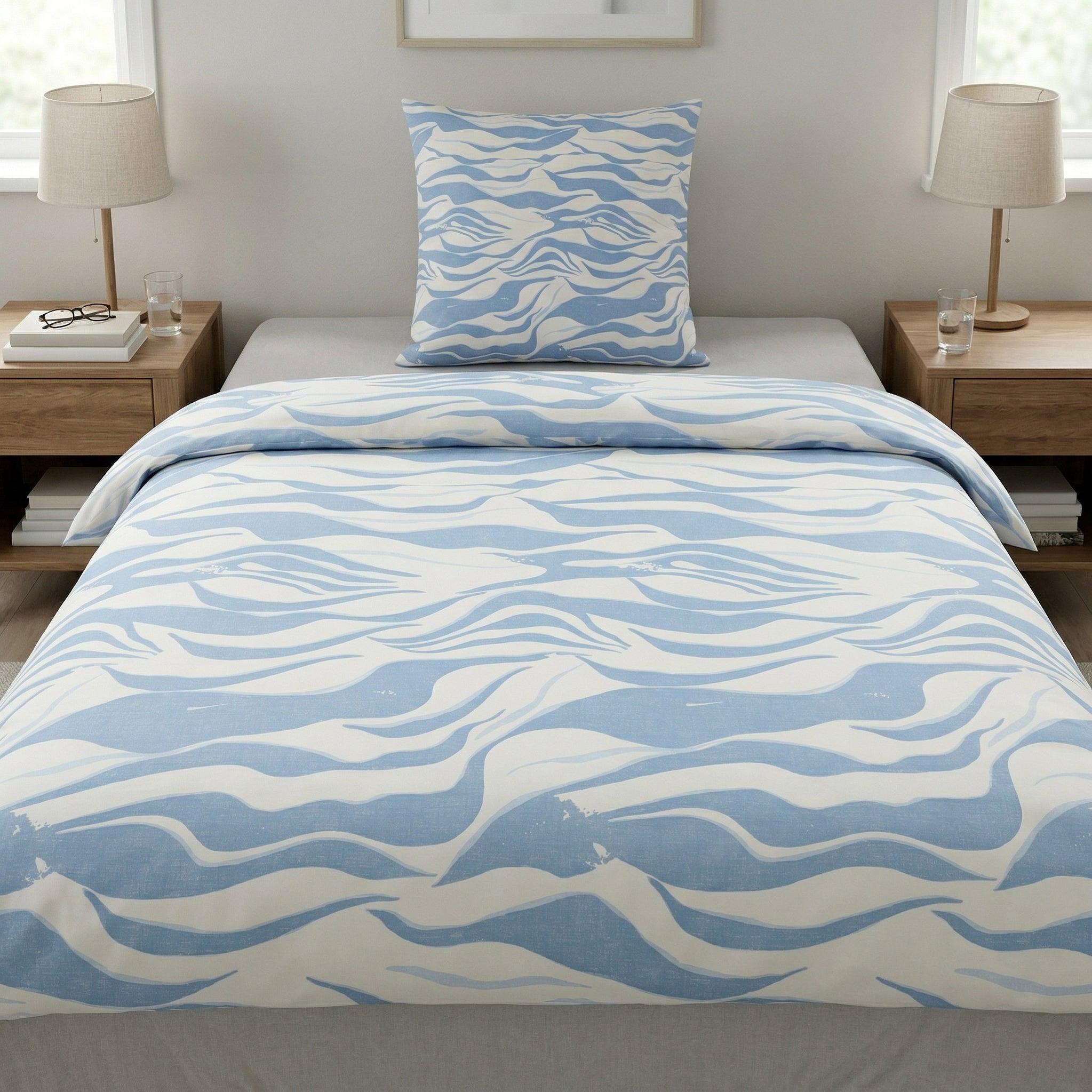 Bettwäsche in Weiß und Hellblau mit Wellenmuster im Schlafzimmer.