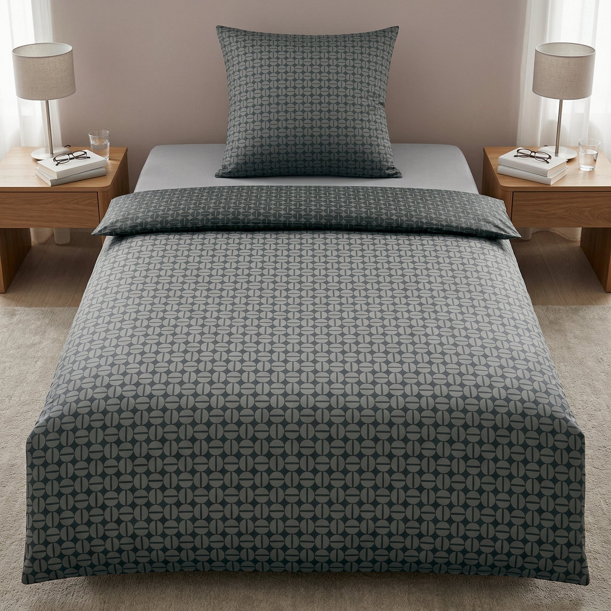 Graue Bettwäsche mit Muster im Schlafzimmer, Nachttische mit Lampen.