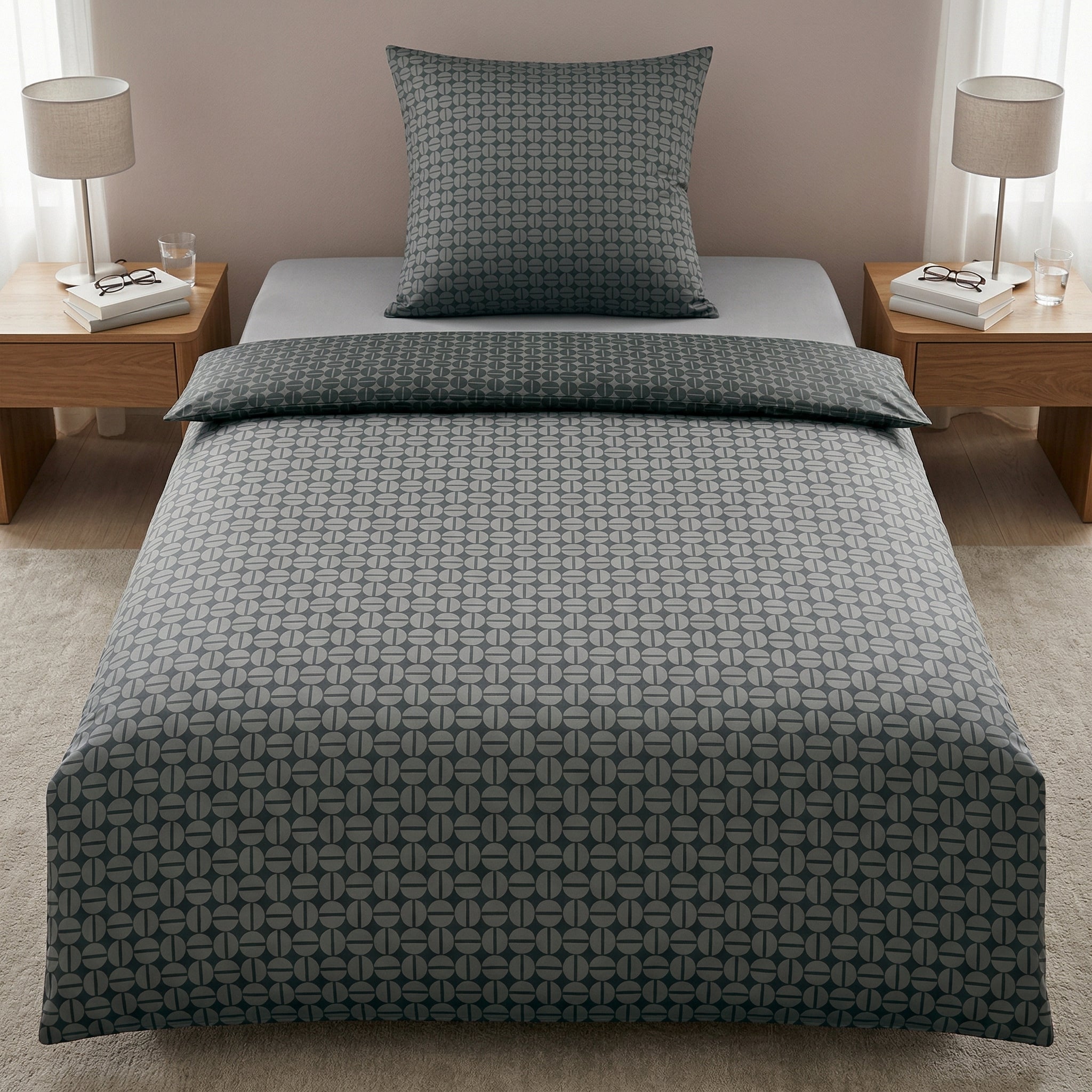 Graue Bettwäsche mit Muster im Schlafzimmer, Nachttische mit Lampen.