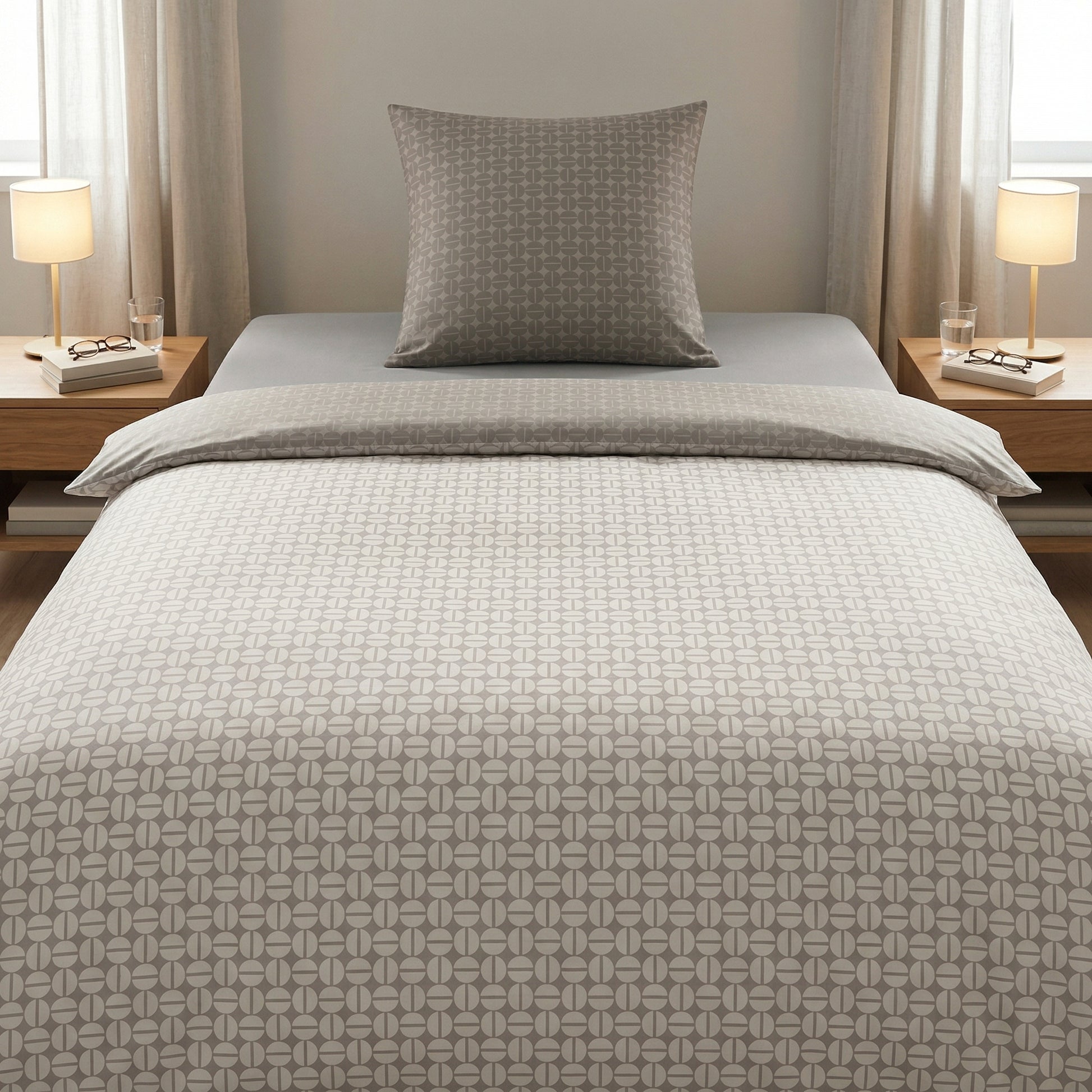 Graue Bettwäsche mit grafischem Muster auf einem modernem Bett.