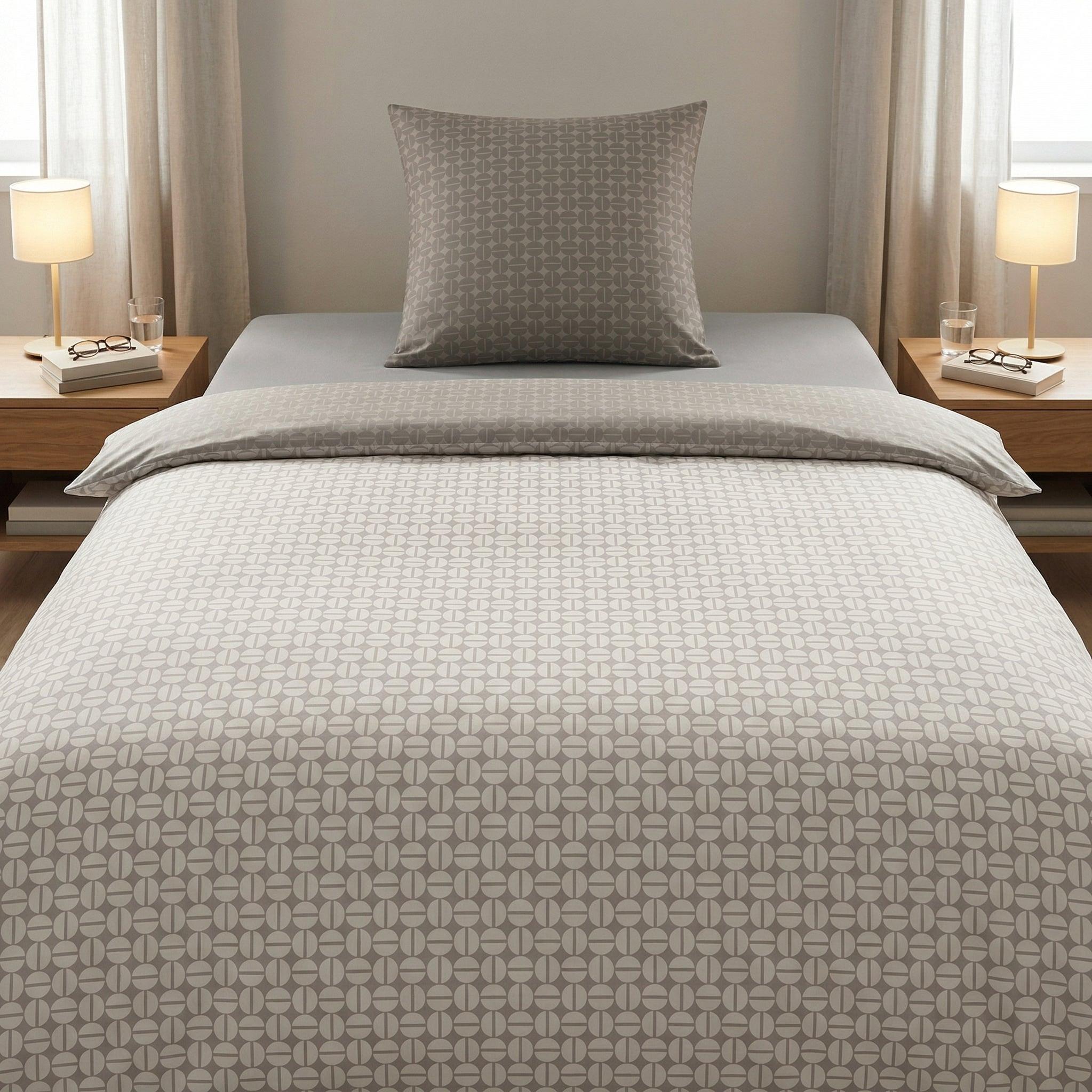 Graue Bettwäsche mit grafischem Muster auf einem modernem Bett.