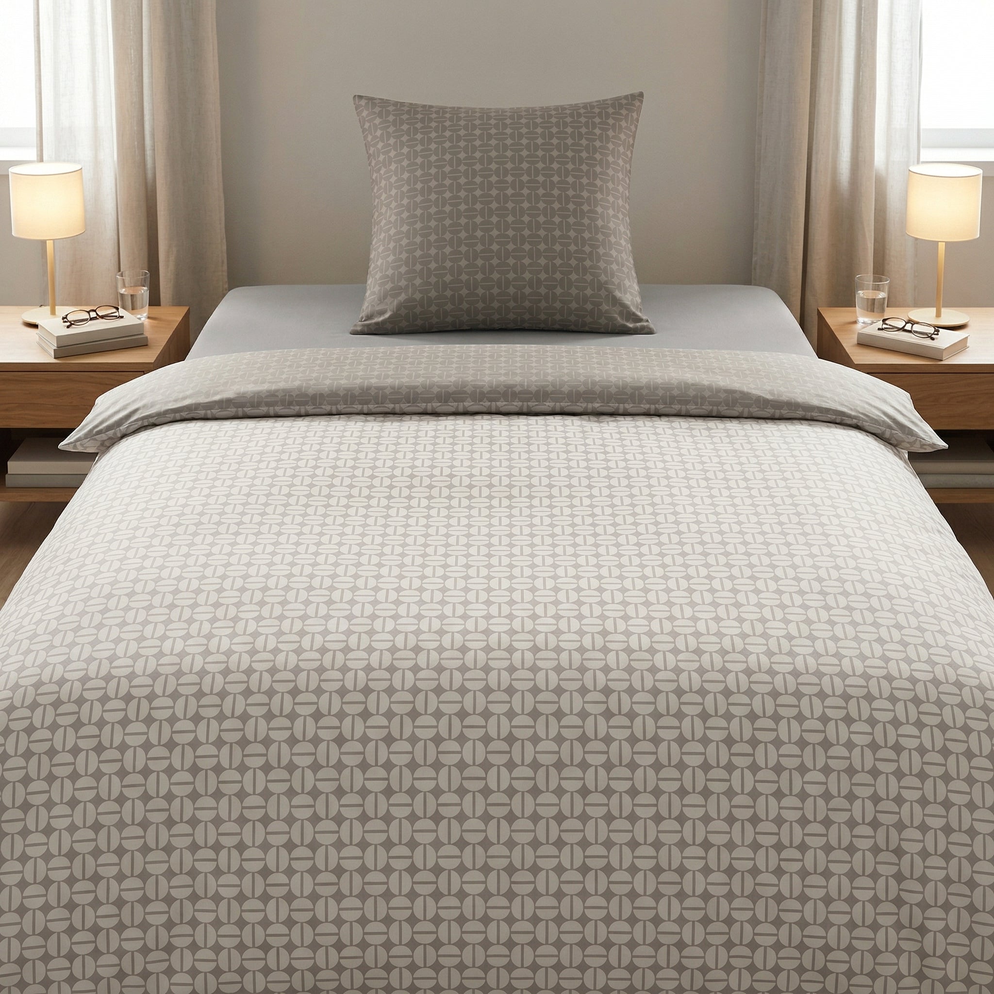 Graue Bettwäsche mit grafischem Muster auf einem modernem Bett.