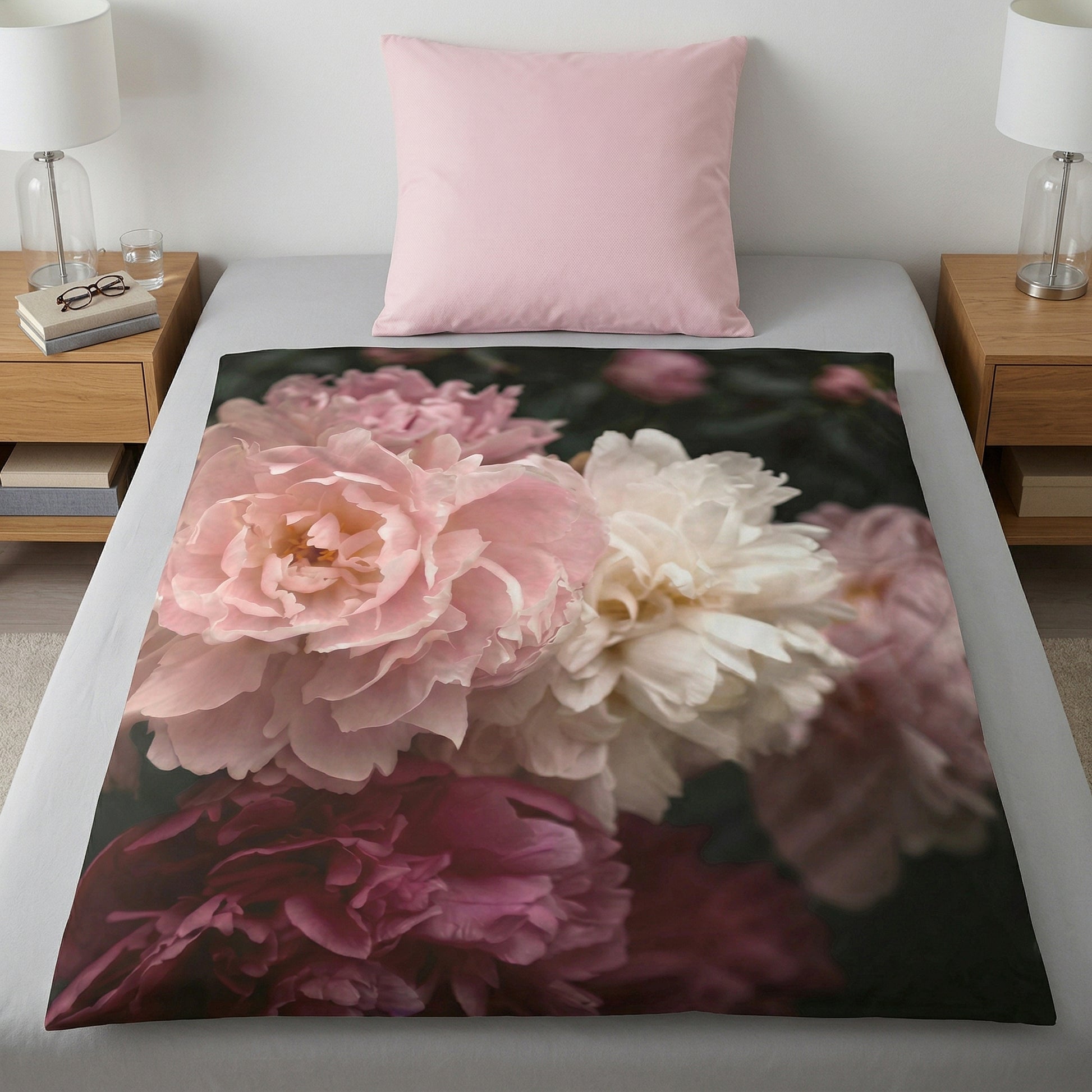 Bettdecke mit großem Blumenmotiv in Rosa und Creme auf Bett.