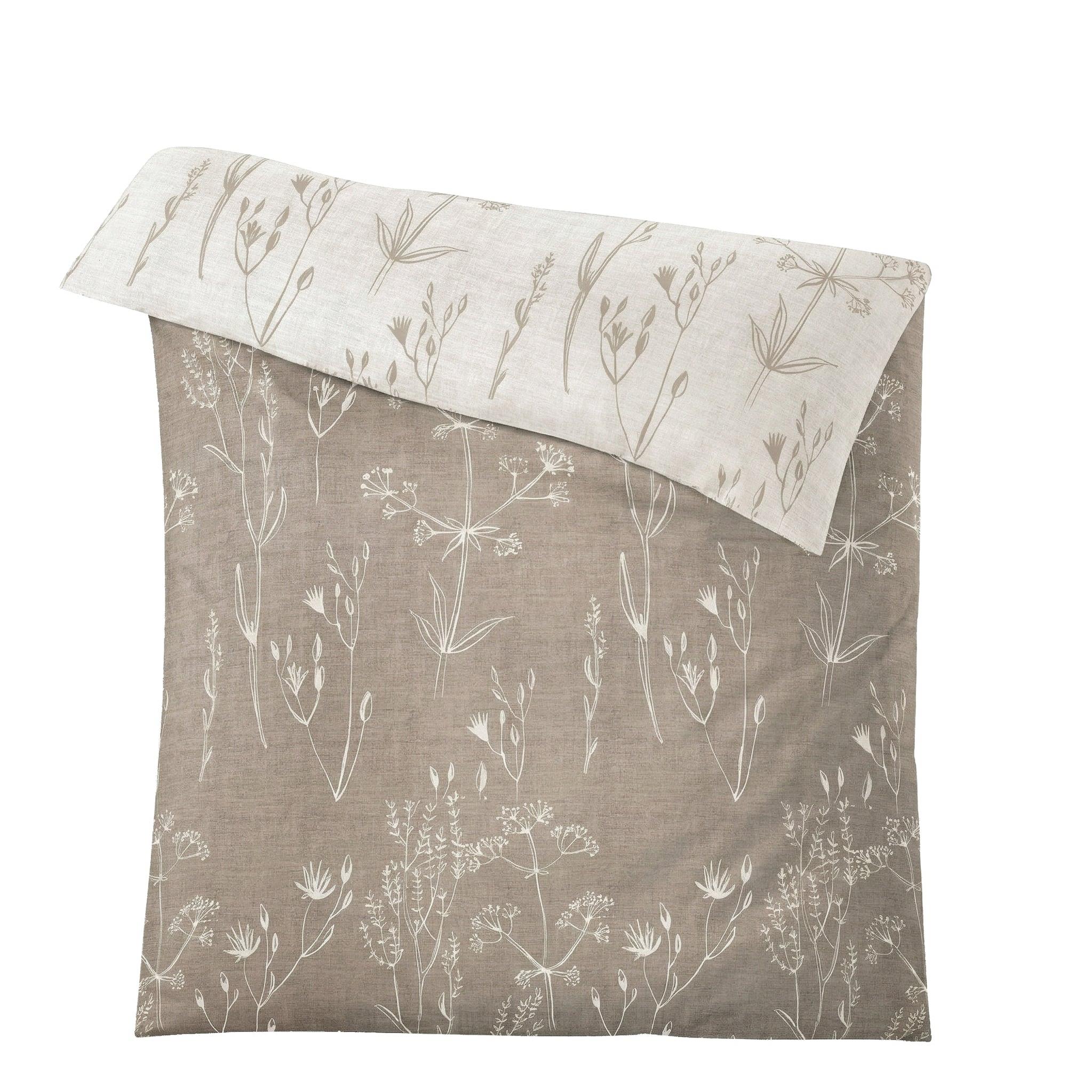 Beige Bettwäsche mit zartem Blumenmuster in Weiß und Taupe.