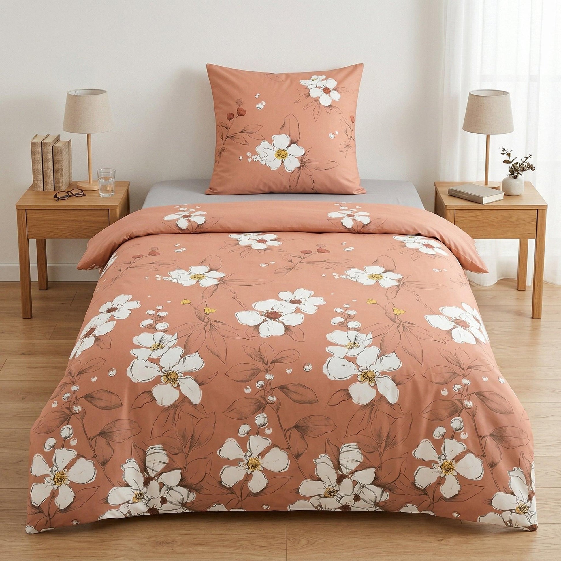 Apricotfarbene Bettwäsche mit weißen Blumen im Schlafzimmer.