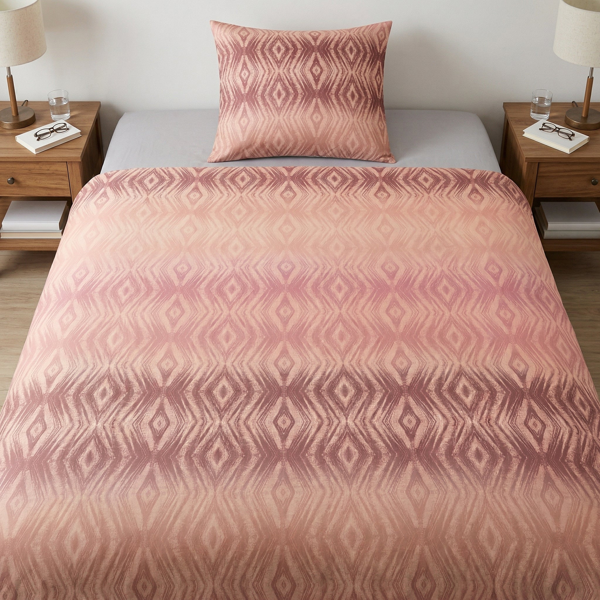 Rosa Bettwäsche mit geometrischem Muster auf gemachtem Bett.