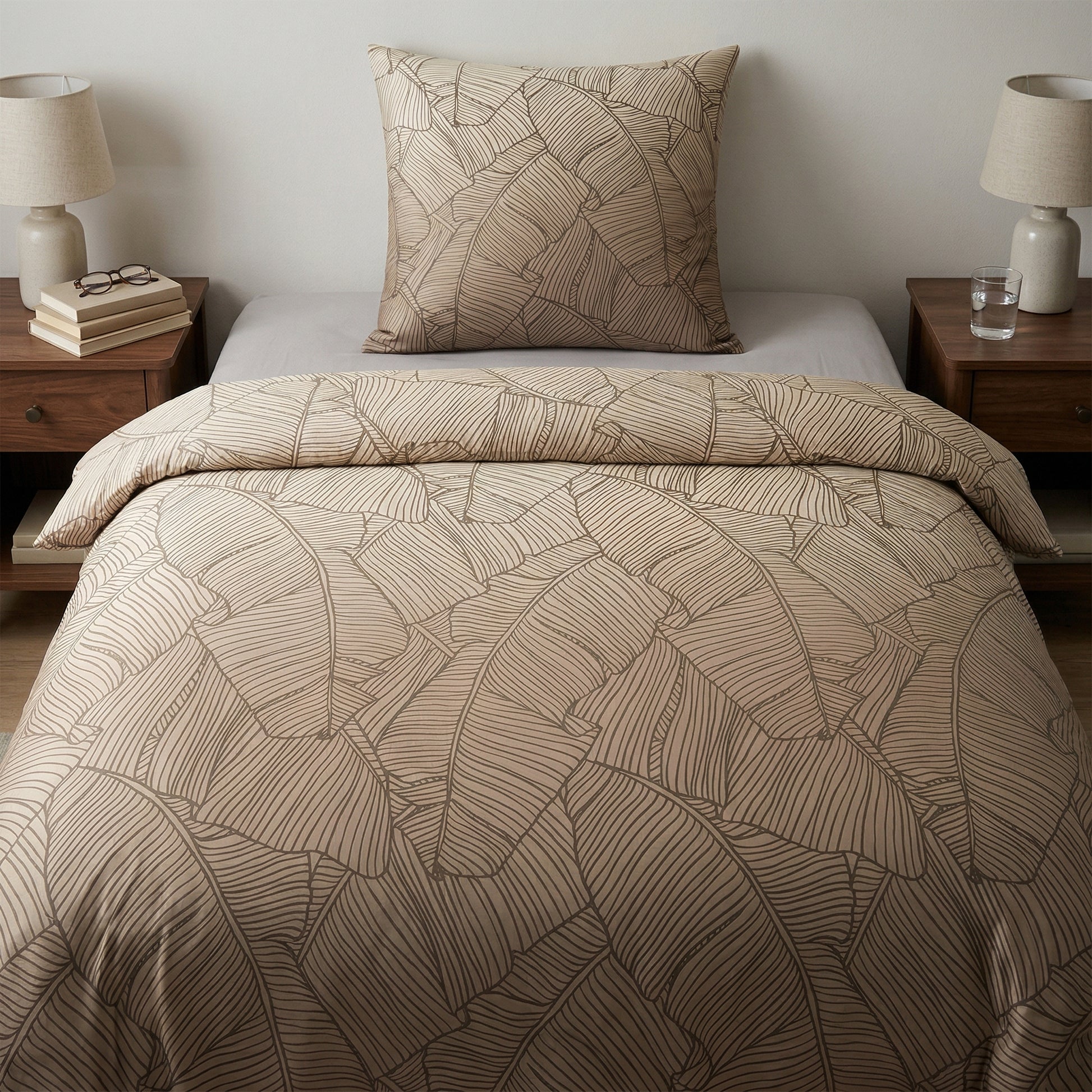 Beige Bettwäsche mit Blättermuster auf modern gemachtem Bett.