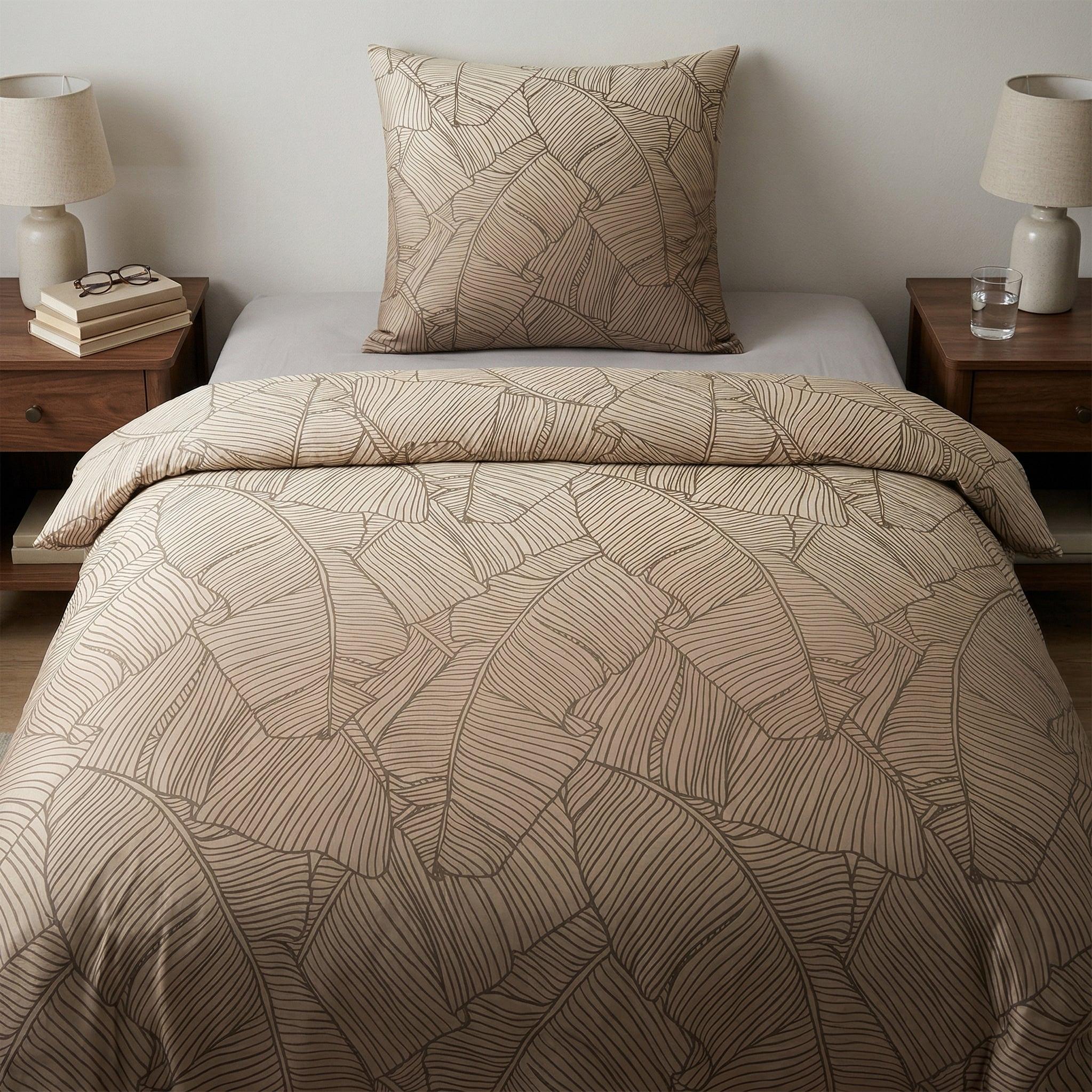 Beige Bettwäsche mit Blättermuster auf modern gemachtem Bett.