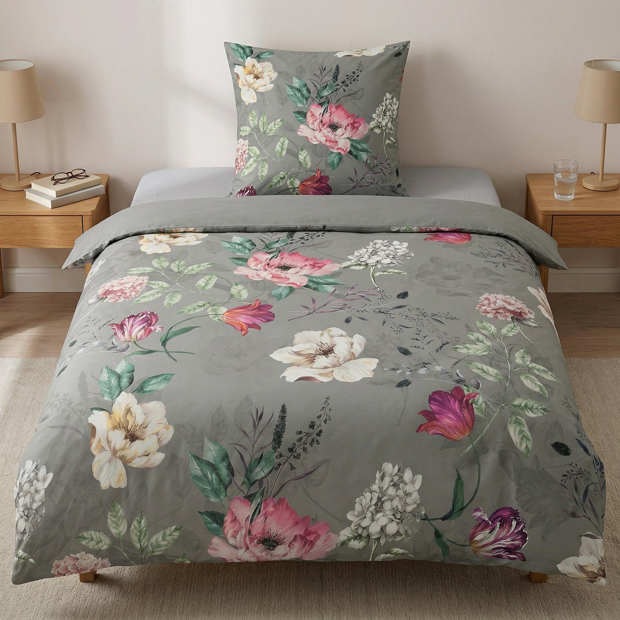 Graue Bettwäsche mit großem Blumenmuster auf modernem Bett.