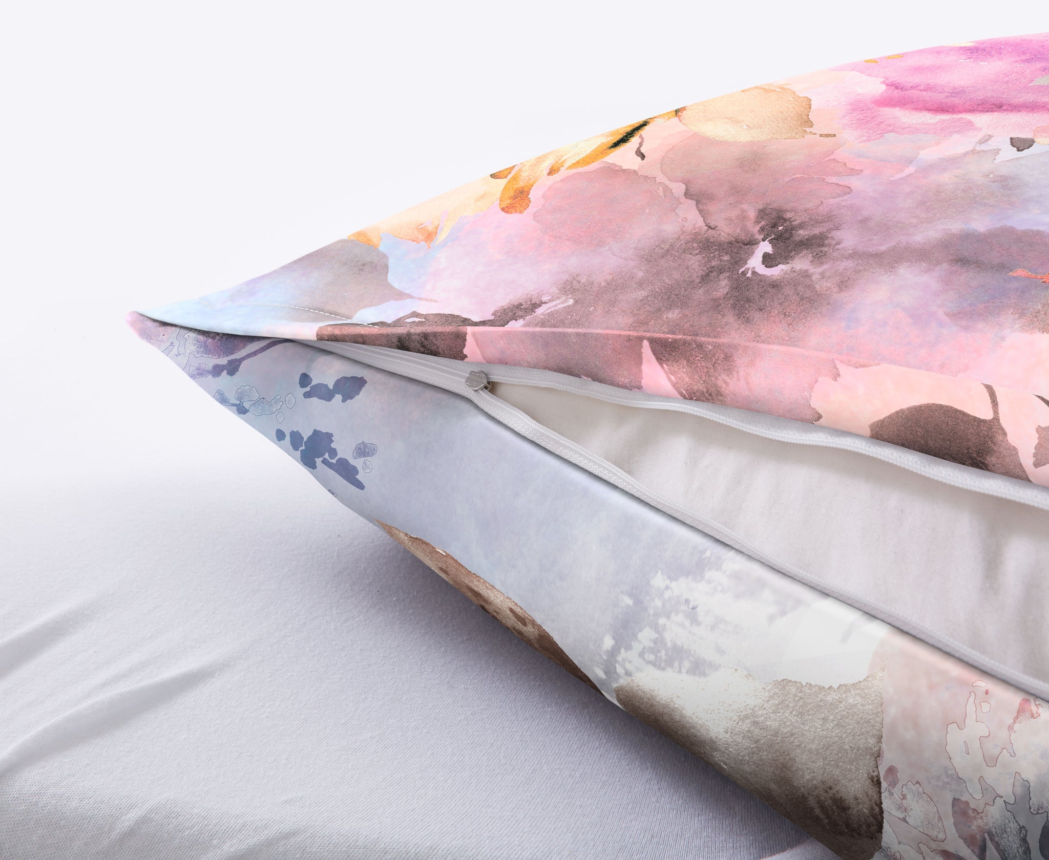 Nahaufnahme Kissen mit Aquarell-Blumenbezug und sichtbarem Reißverschluss