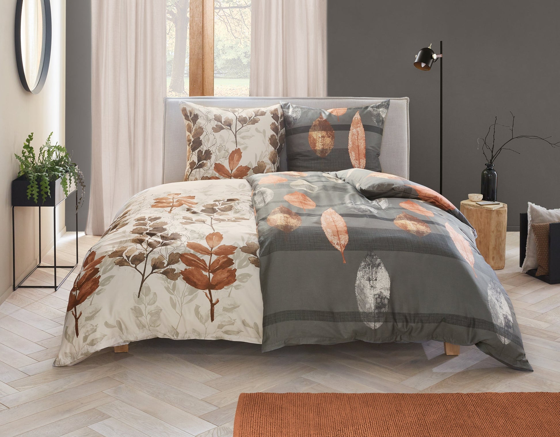 Bett mit herbstlicher Bettwäsche in Grau und Beige mit Blätterdruck
