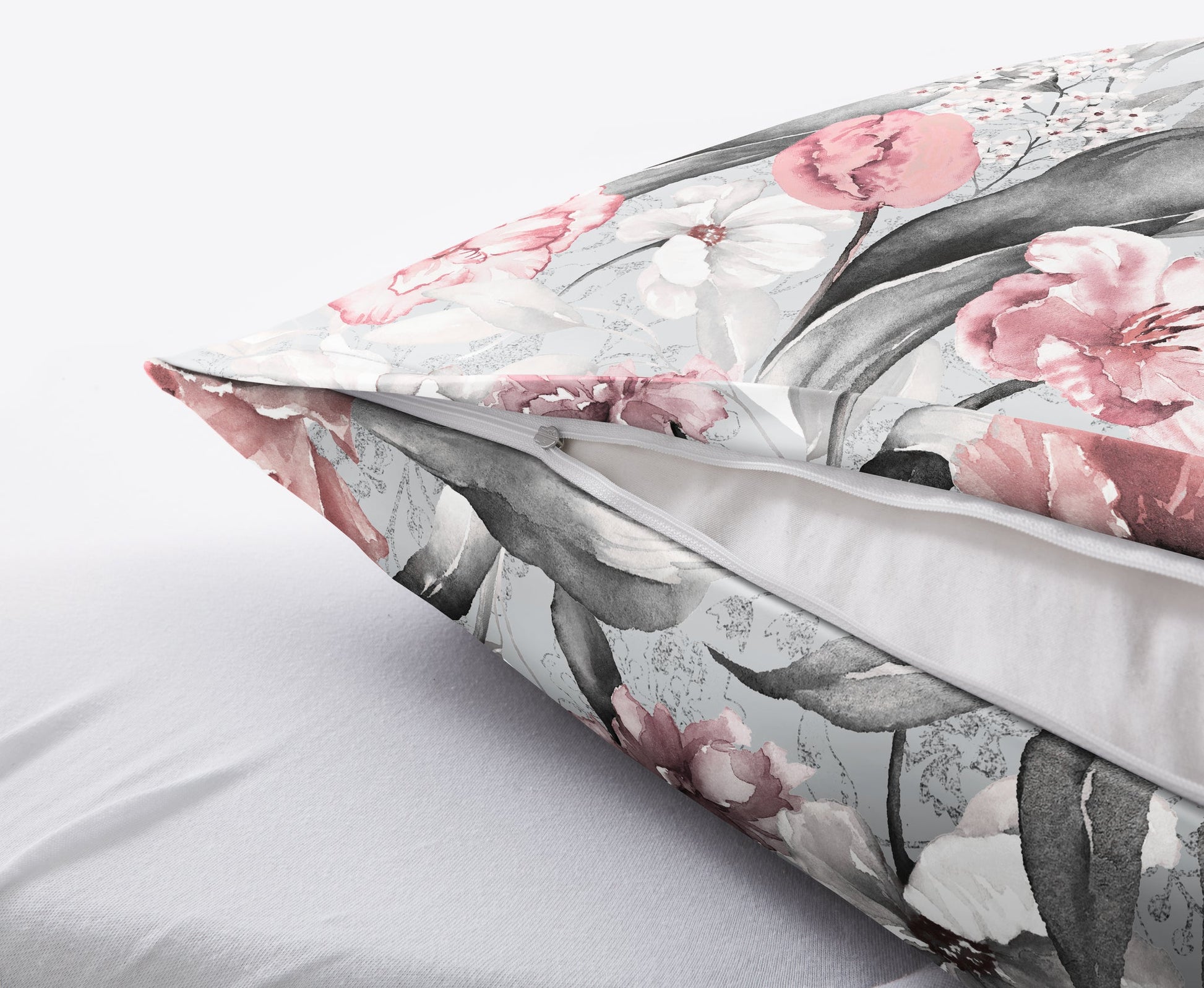 Floraler Kissenbezug mit Reißverschluss auf weichem, hellem Bettlaken