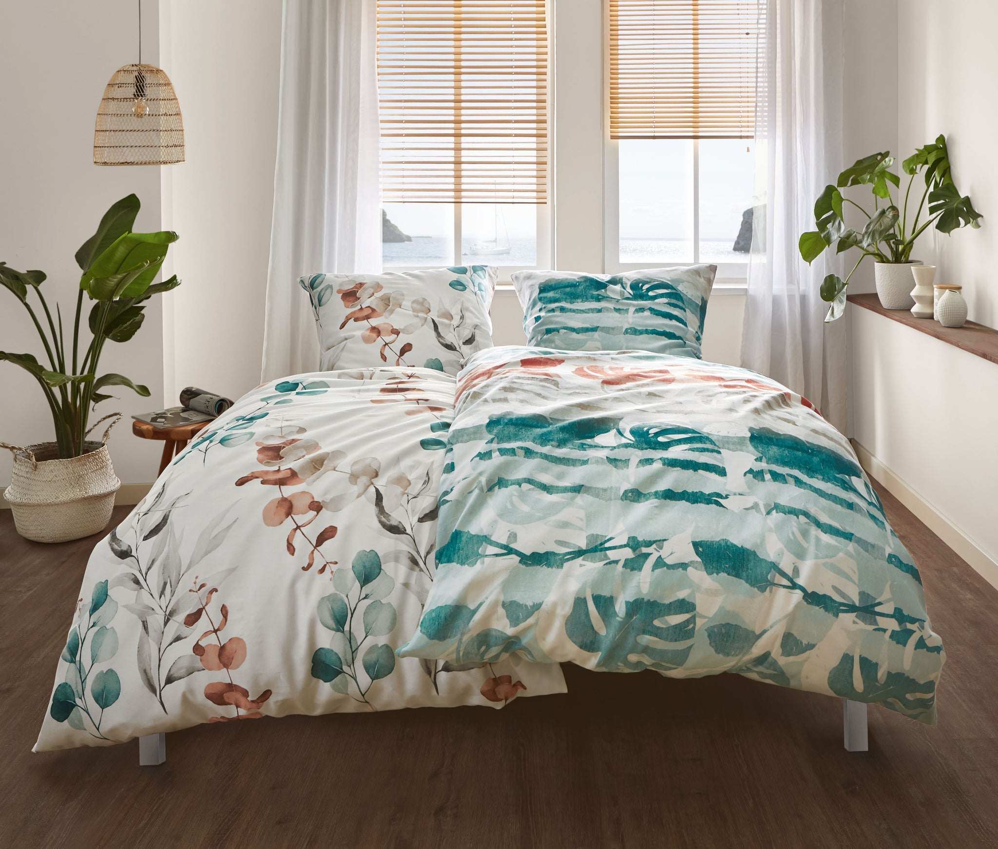 Doppelbett mit bunter Bettwäsche und Pflanzen in hellem Schlafzimmer