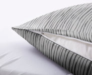 Nahaufnahme eines grauen Kissenbezugs mit Reißverschluss auf Bett