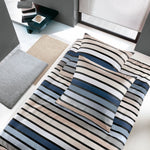 Bett mit gestreifter Bettwäsche in Beige, Blau, Grau und Weiß