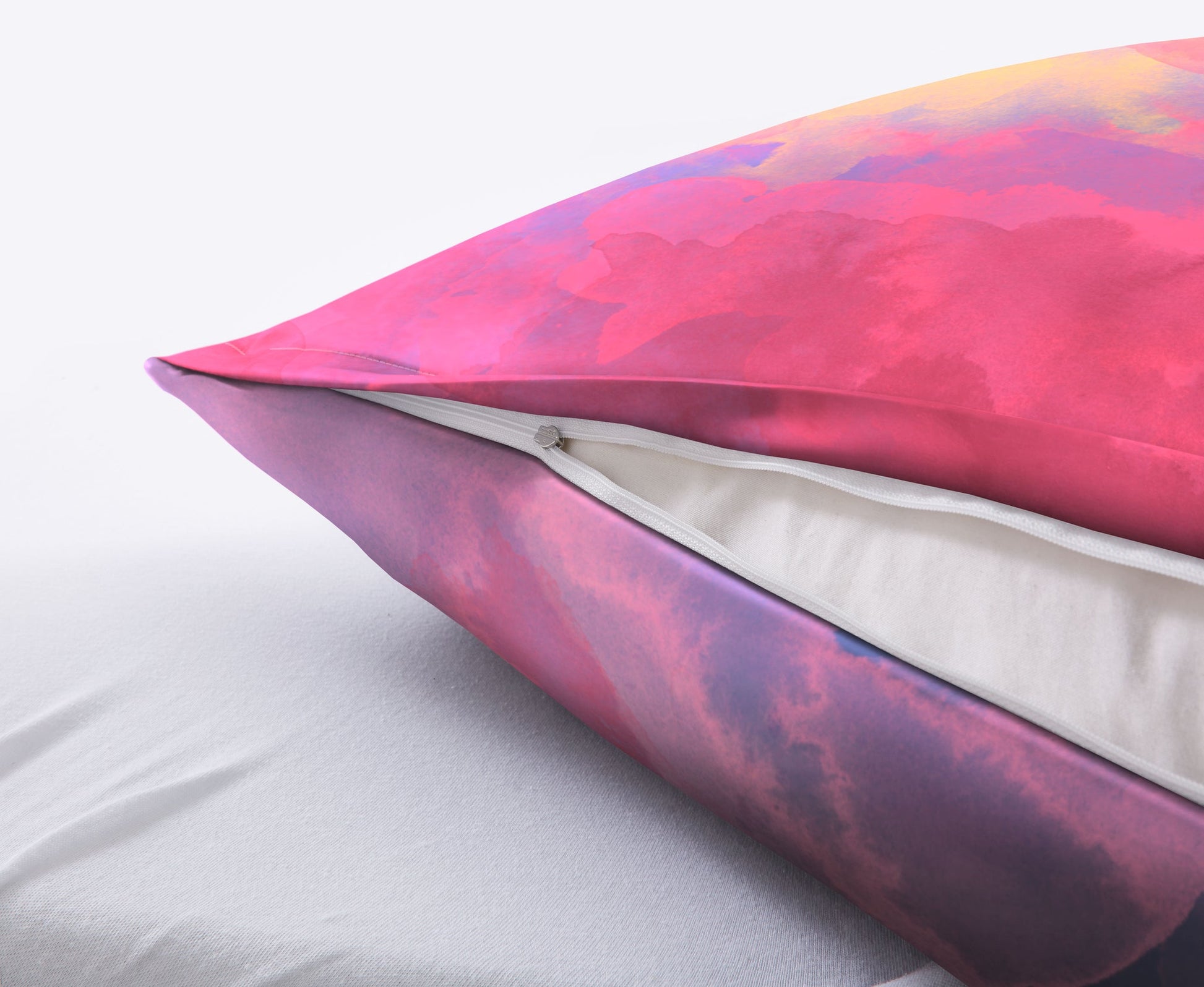 Buntes Kissen mit Reißverschluss auf weißer Unterlage in Nahaufnahme