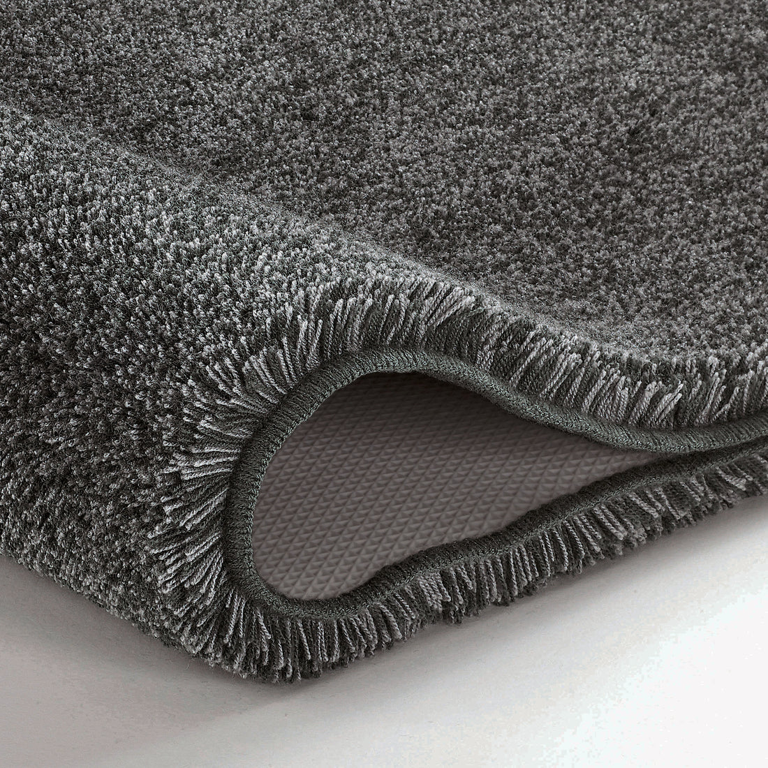 Anthrazitfarbener Badteppich mit weichem Flor und rutschfester Rückseite in Nahaufnahme.