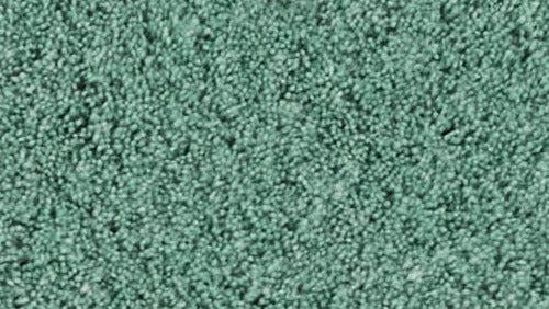 Nahaufnahme eines grünen Badteppichs mit dichter, weicher Schlingenstruktur.