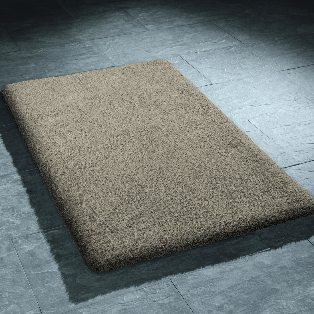 Rechteckiger grauer Badematte Kleine Wolke Grandezza liegt auf dunklem Fliesenboden.