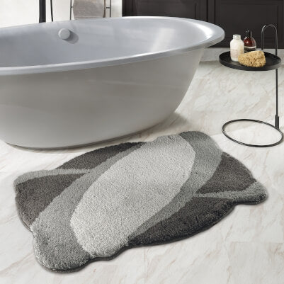 Graue Badematte in Blattform vor freistehender Badewanne im Bad.