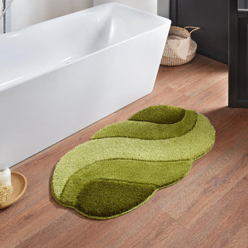 Grüner, geschwungener Badteppich auf Holzfußboden neben Badewanne