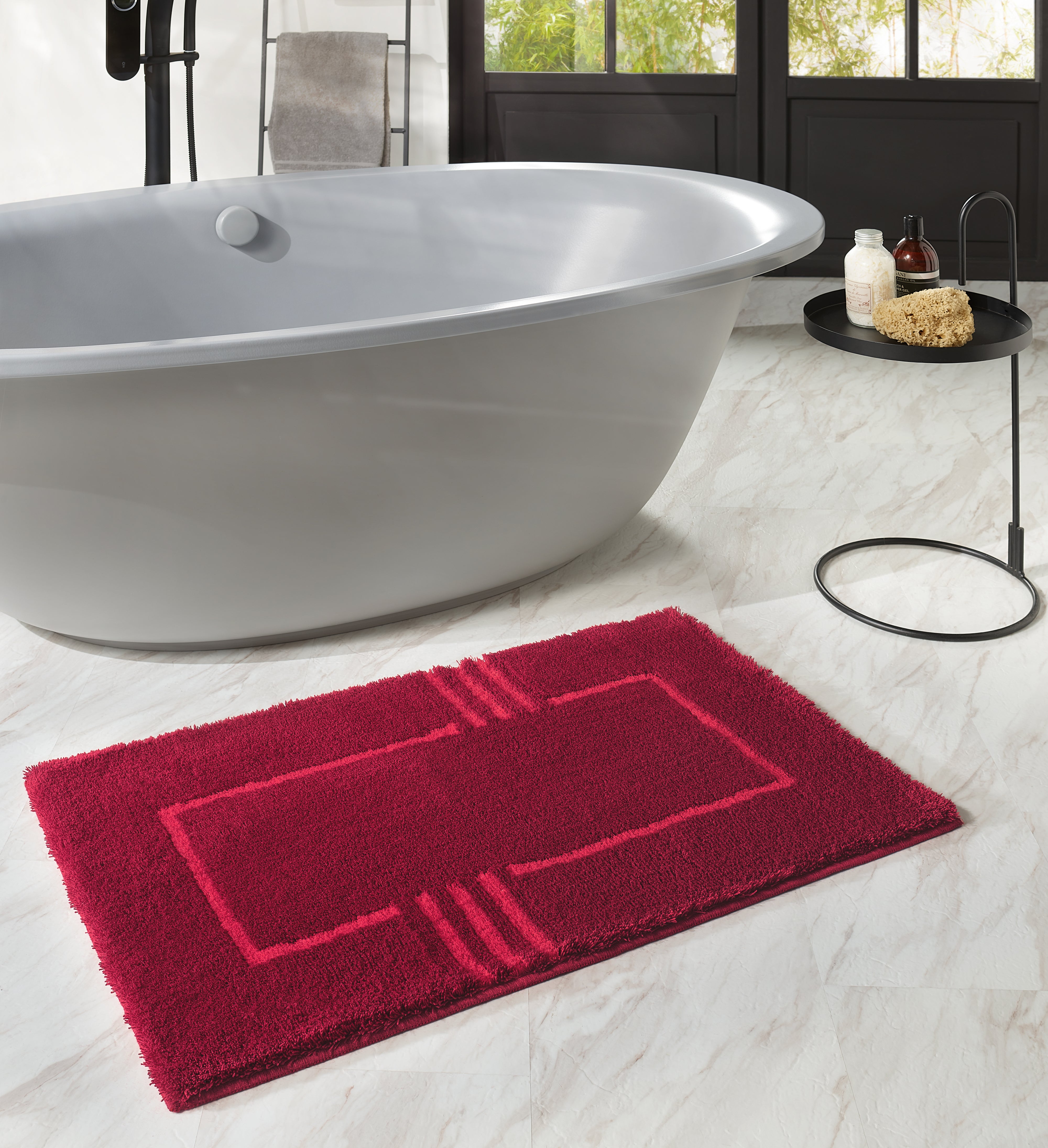 Kleine Wolke Creativo Interno Badematte in Rot vor freistehender Badewanne im modernen Bad.