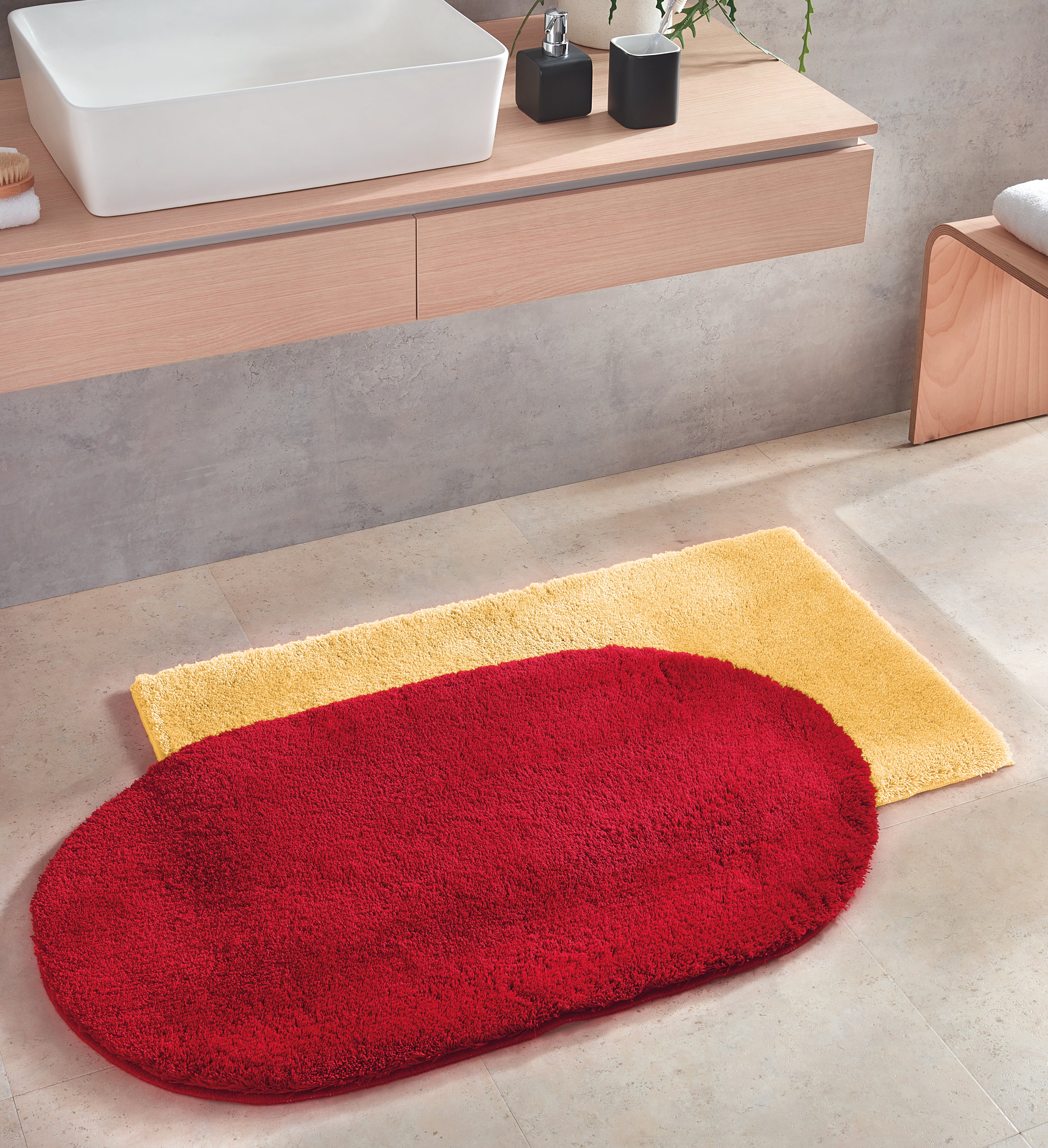 Das Bild zeigt zwei Creato Relax Badteppiche in Rot und Gelb