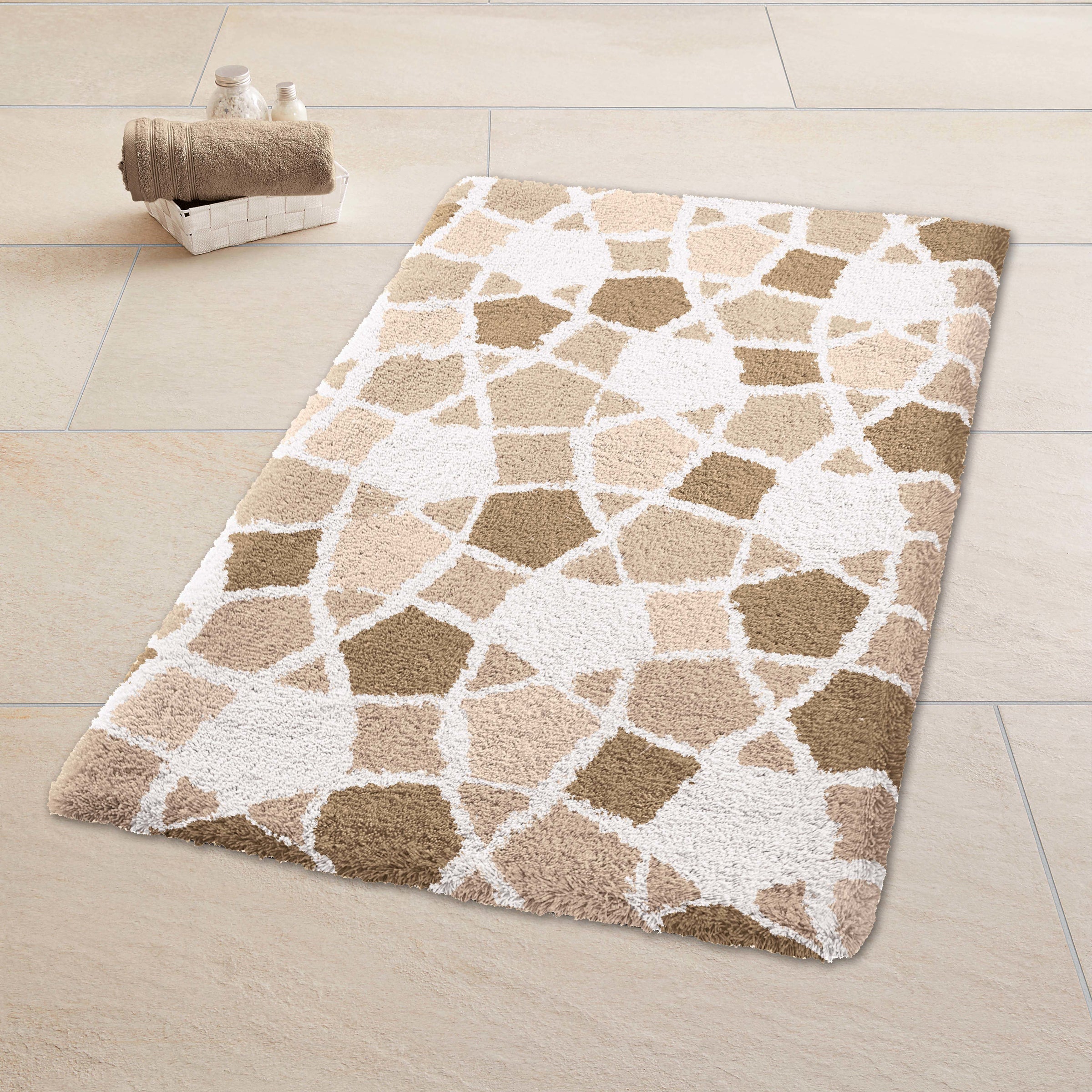 Beiger Badteppich Kleine Wolke Sintra mit weißem Mosaikmuster liegt auf hellem Fliesenboden.