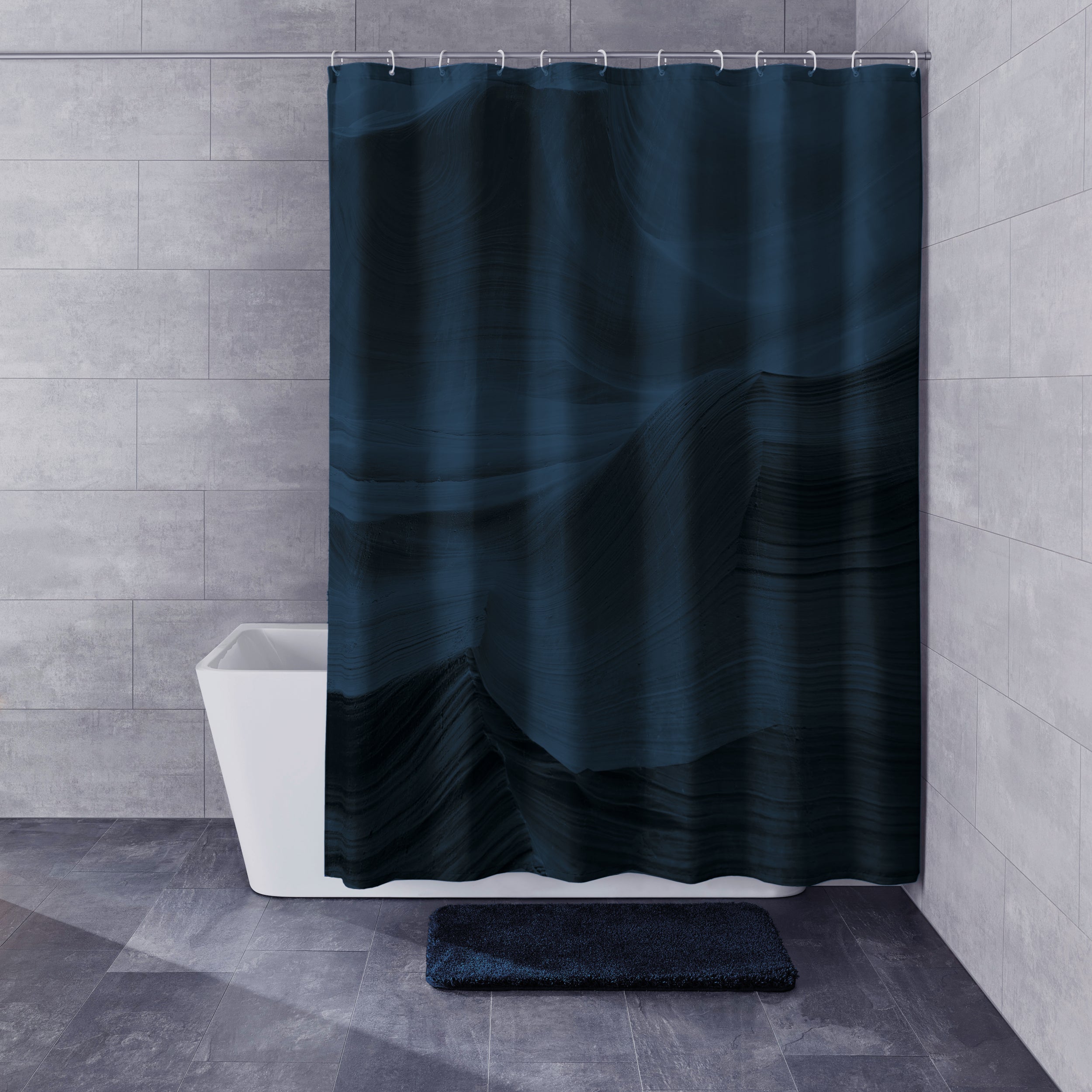 Duschvorhang Mystic Night von Kleine Wolke hängt im modernen Bad mit grauen Fliesen und dunkelblauer Badematte.