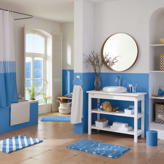 Helles Badezimmer mit weißen Möbeln und blauen Akzenten im mediterranen Stil.