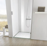 Moderne Dusche mit weißer Duschmatte, Handbrause und Handtuchstapel