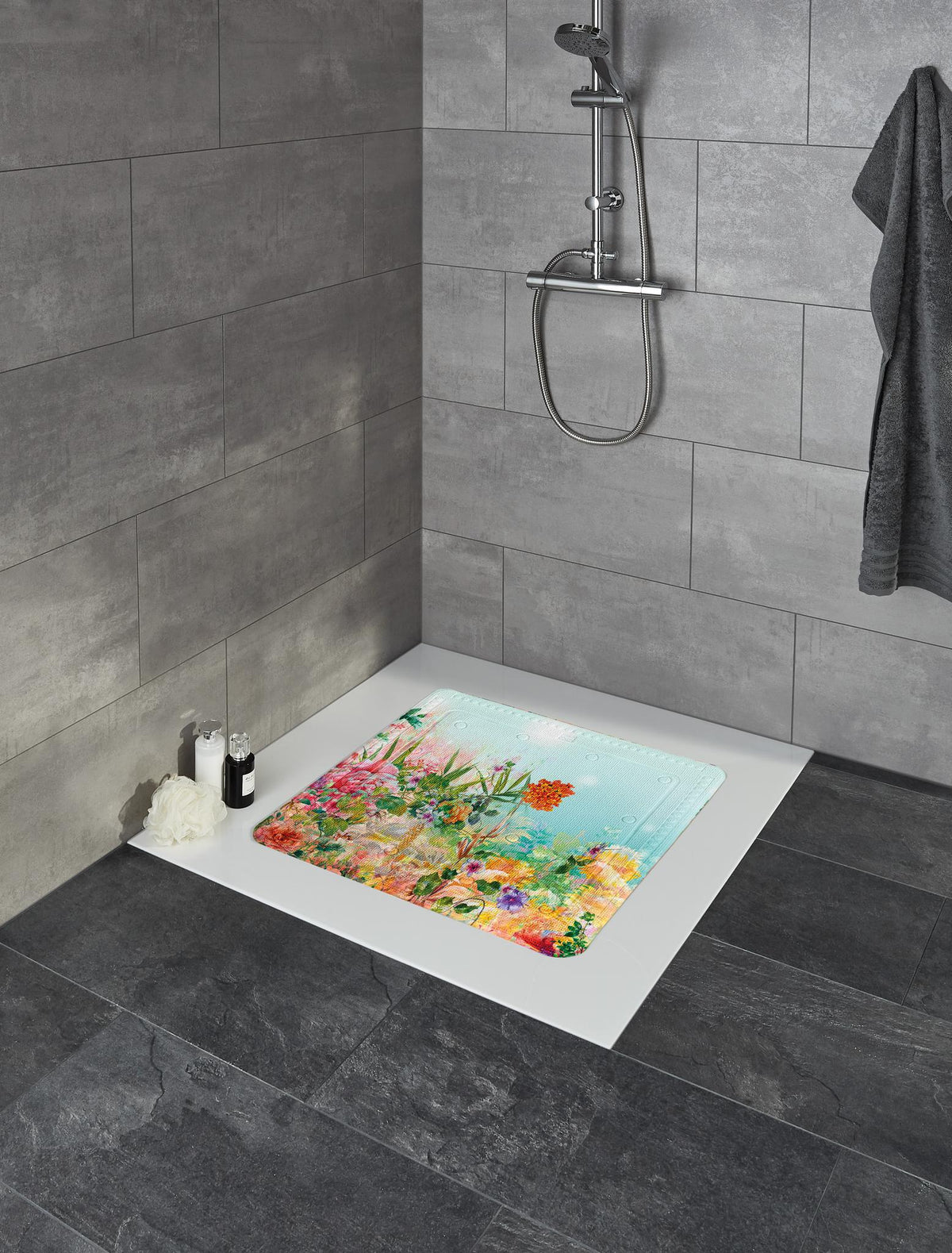 Bunte Antirutschmatte mit Blumenmotiv in moderner Dusche mit grauen Fliesen.