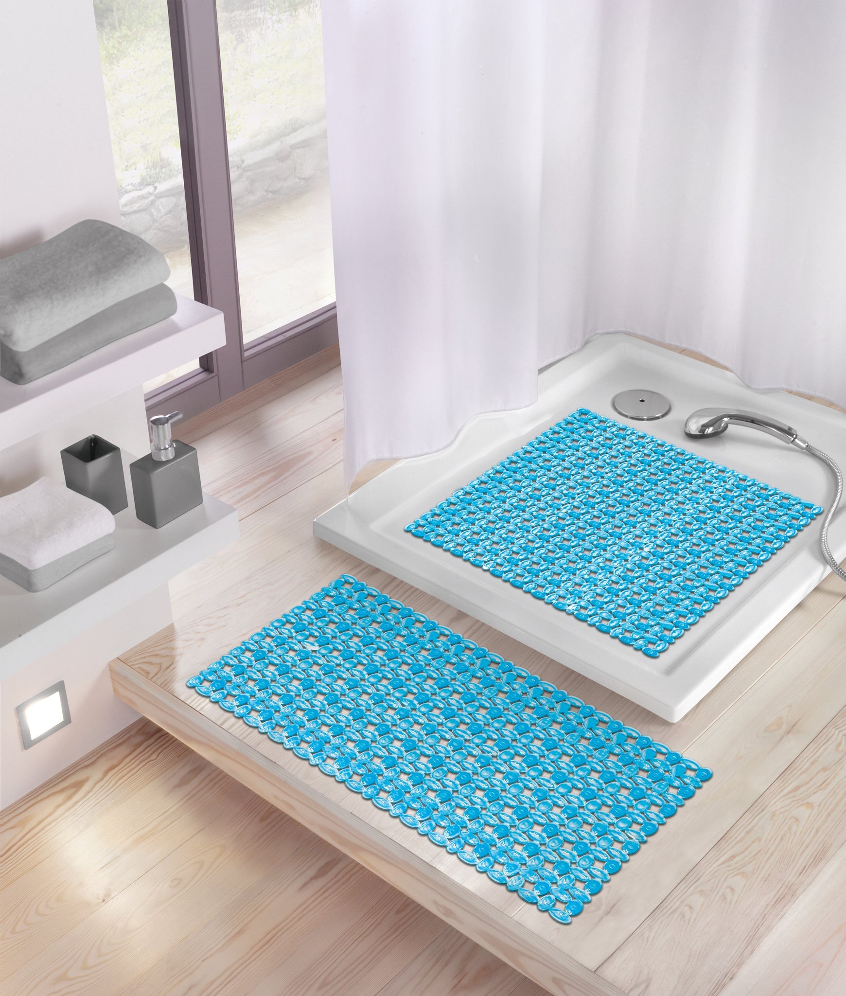 Duscheinlage IVY in Türkis 54x54 cm liegt in einer weißen Duschwanne mit Handbrause.