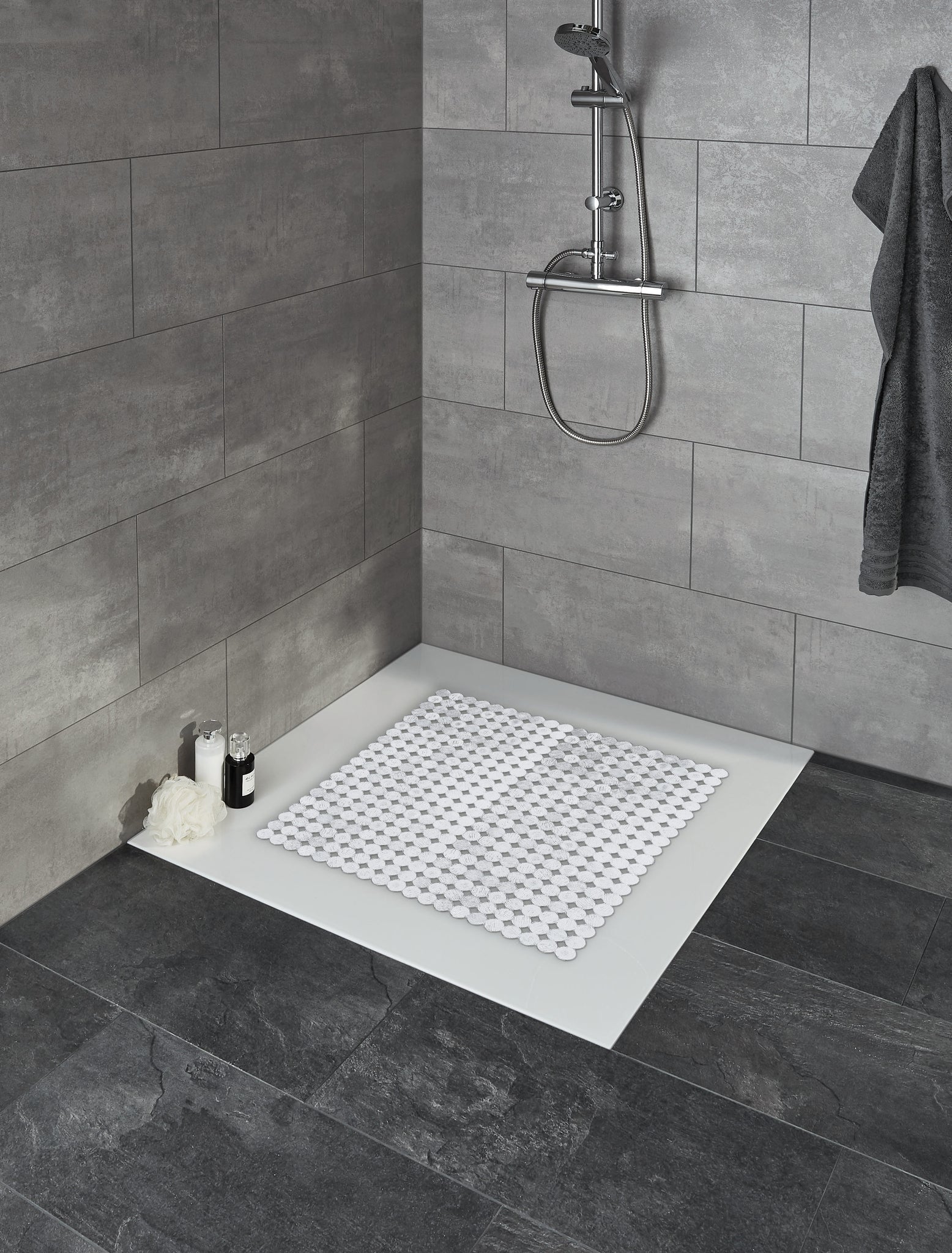 Duscheinlage SIGN Clear 55 x 55 cm in moderner Dusche mit grauen Fliesen liegt auf dem Duschboden.