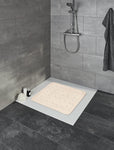 Rutschfeste beige Badematte in gefliester Dusche mit Duschkopf an Wand