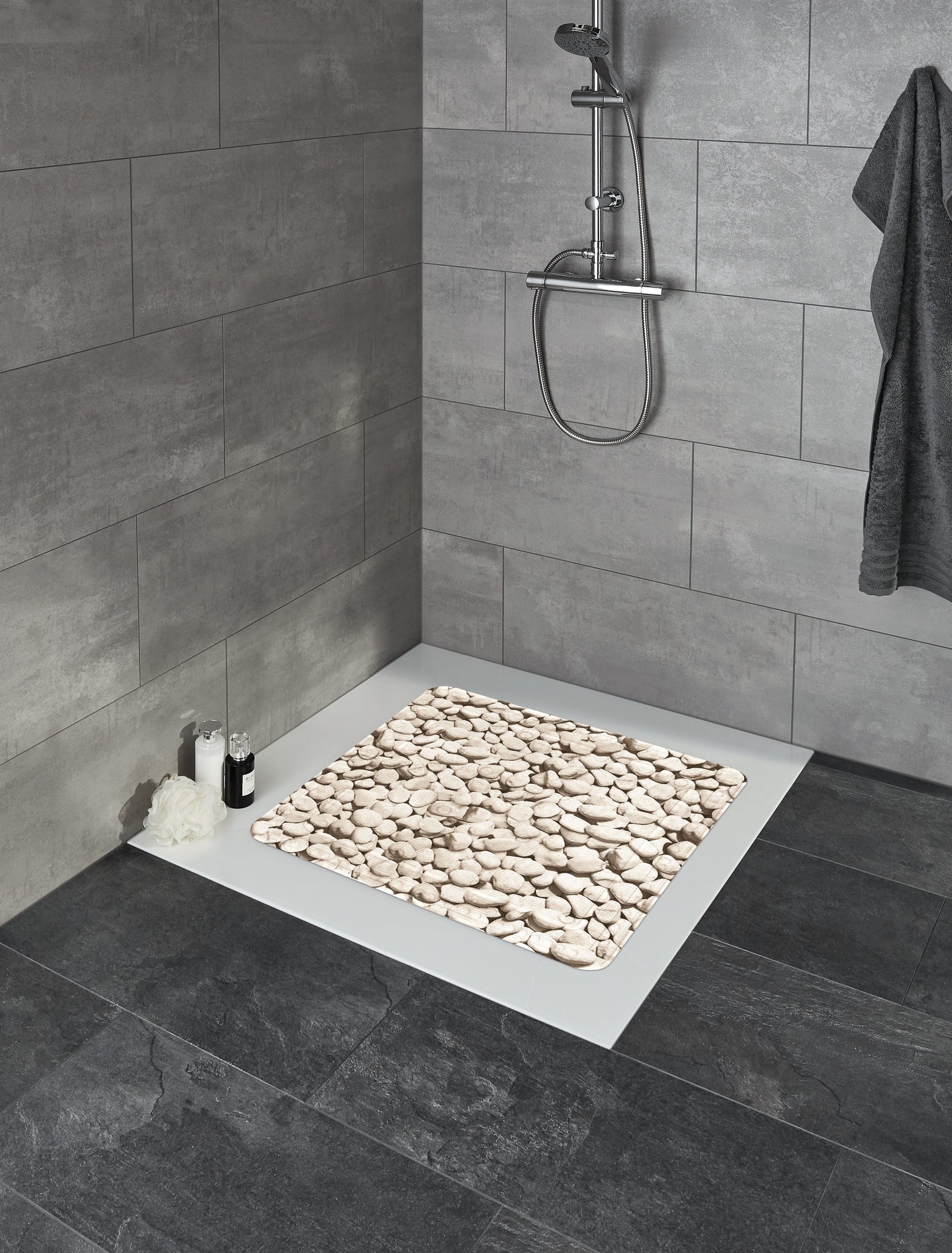 Duscheinlage STEPSTONE Natur 55 x 55 cm liegt in einer grau gefliesten Dusche mit Duscharmatur.